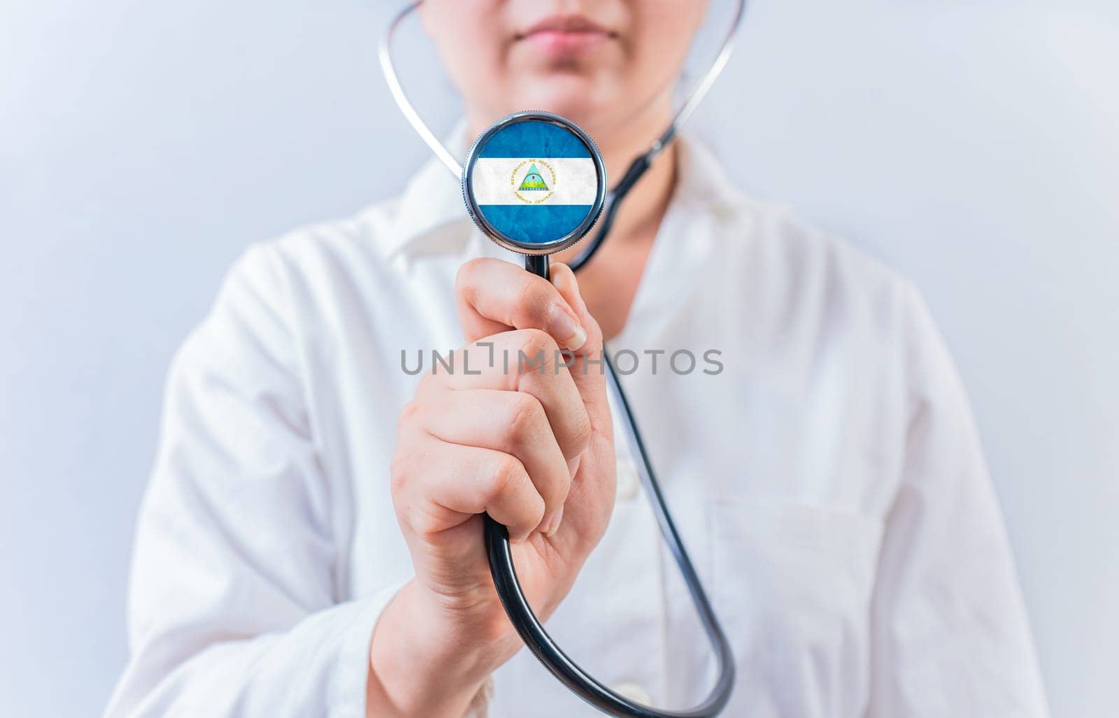 Female doctor holding stethoscope with Nicaragua flag. Nicaraguan Health and Care concept