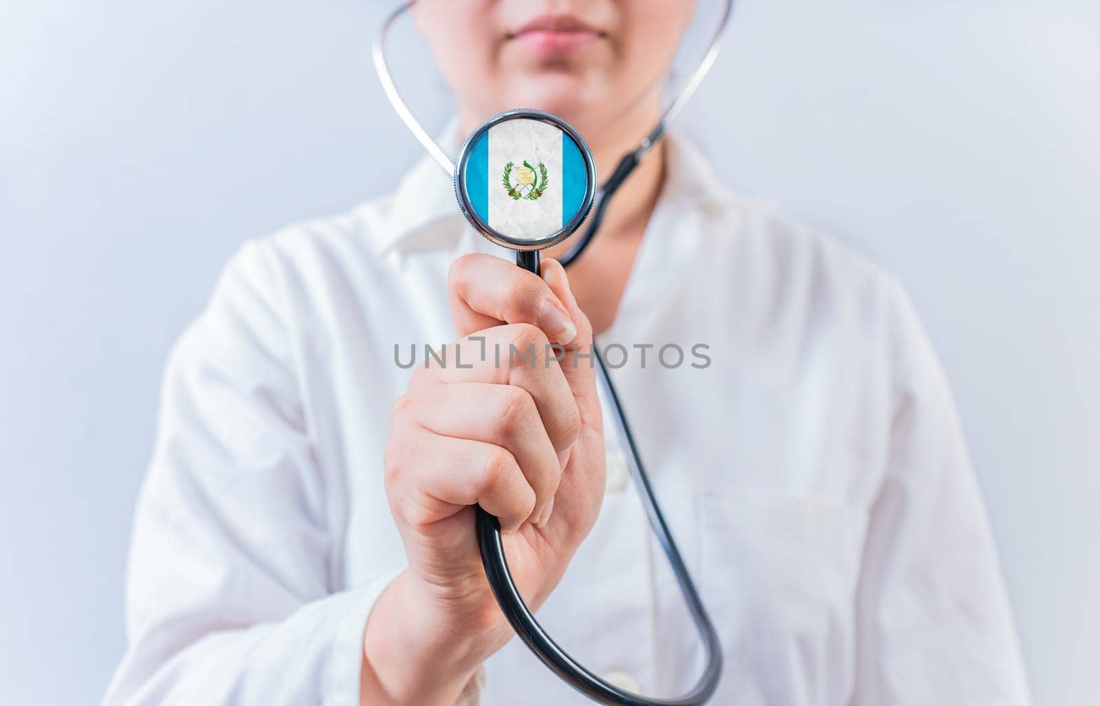 Female doctor holding stethoscope with Guatemala flag. Guatemalan Health and Care concept
