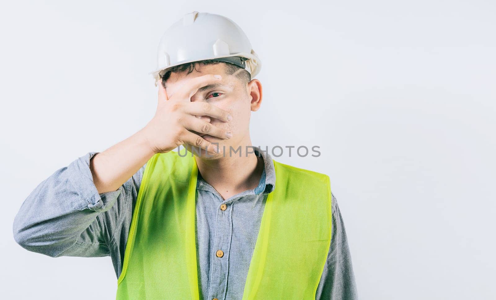 Man engineer with irritated eyes isolated. Young engineer with conjunctivitis on isolated background