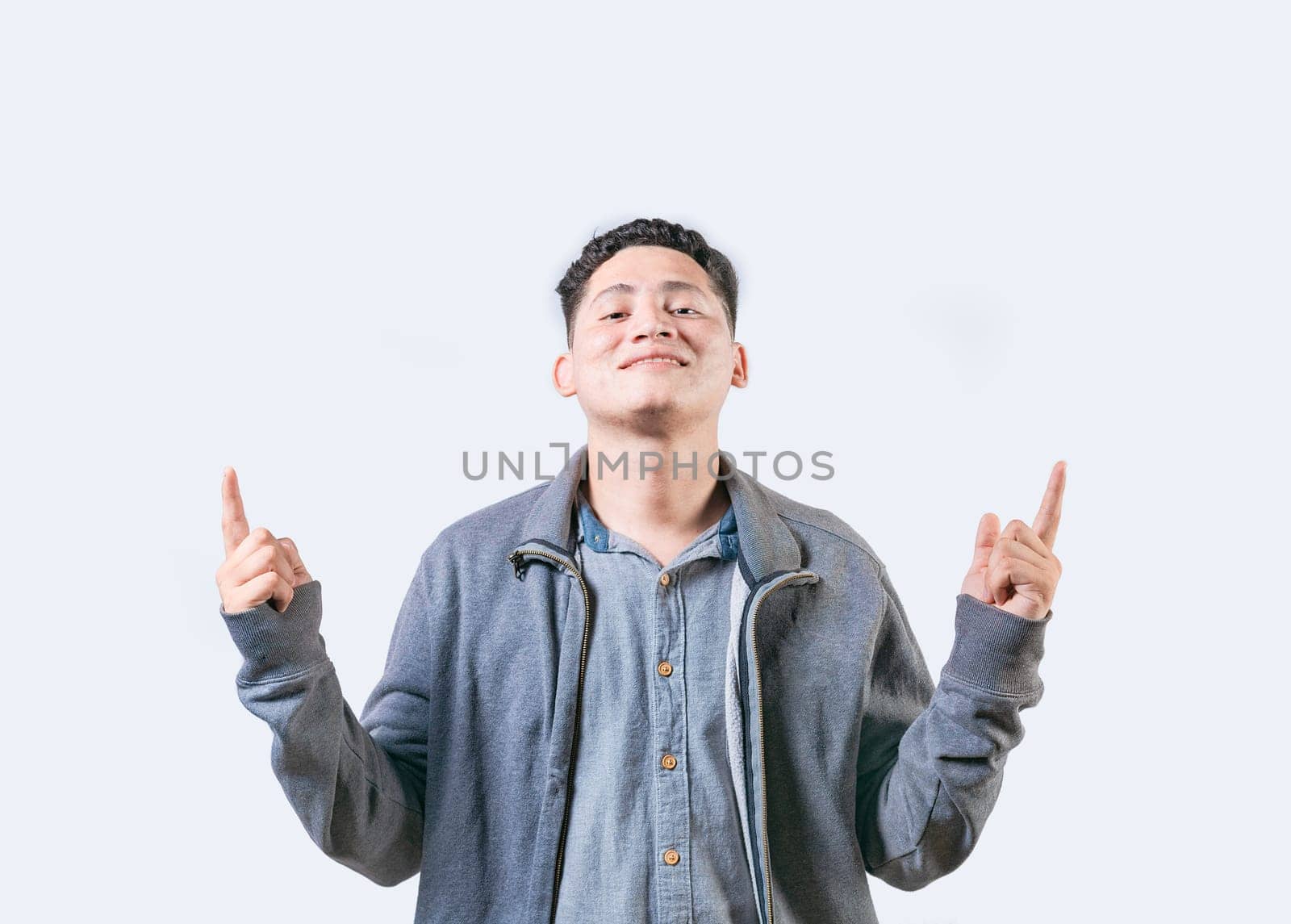 Happy handsome man pointing an advertising up isolated. Young man pointing blank space up and smiling at camera