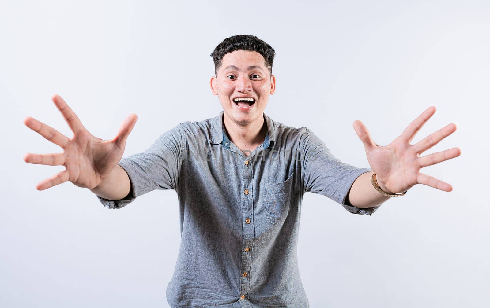 Happy young latin man welcoming with open arms isolated. Hospitable people opening arms to the camera. Smiling man asking for a hug
