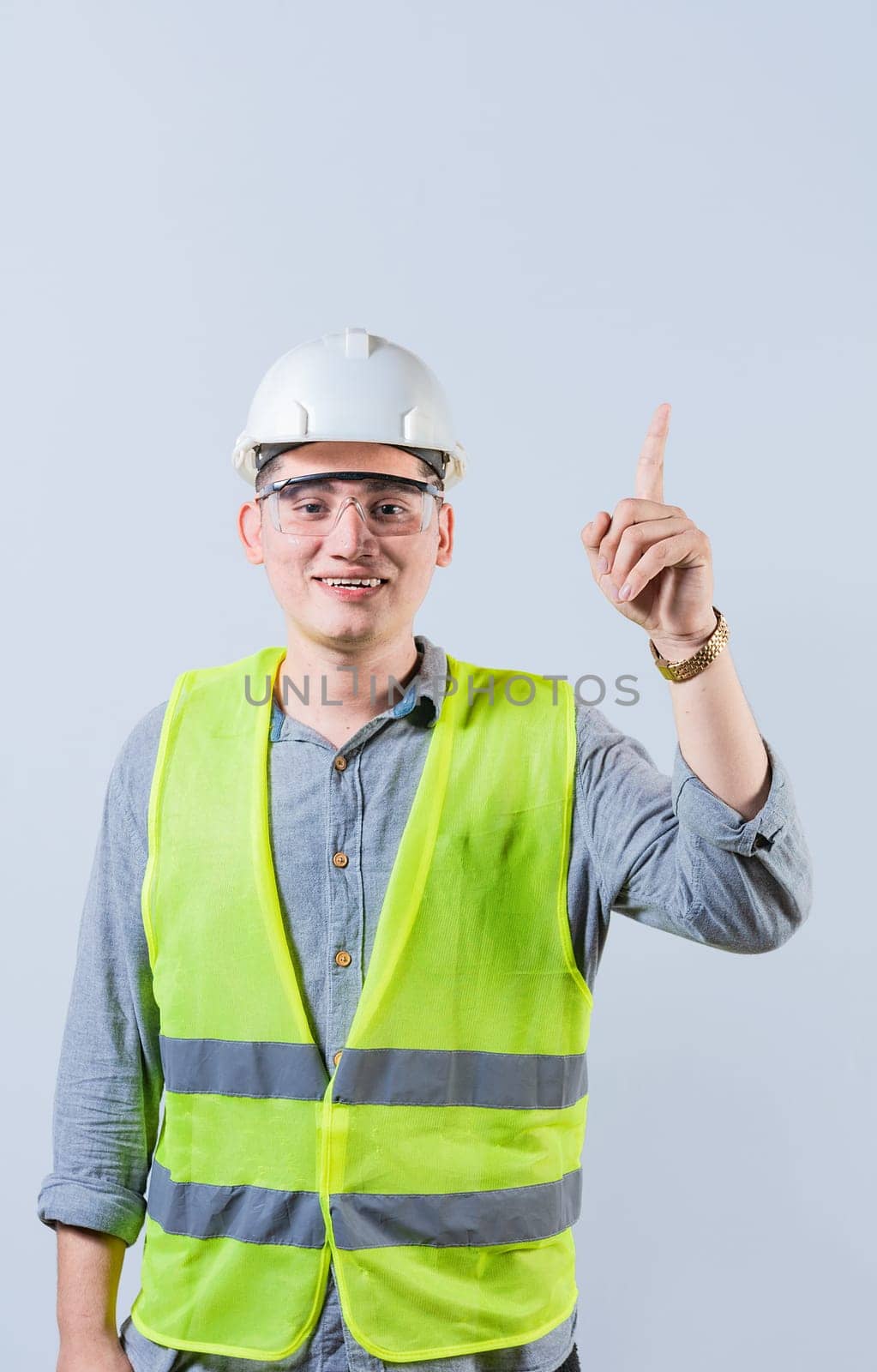 Latin engineer pointing up isolated. Smiling engineer pointing at an advertisement up