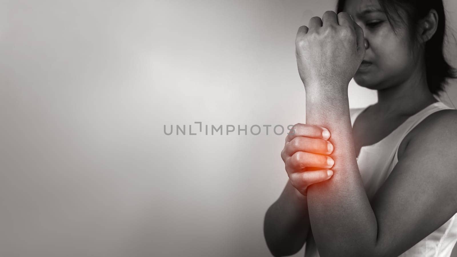 Woman with acute pain elbow with arm pain on gray background, Elbow and arm treatment, Female massaging her elbow muscle spasm, Healthcare and medical concept, Injuries and medical concept.
