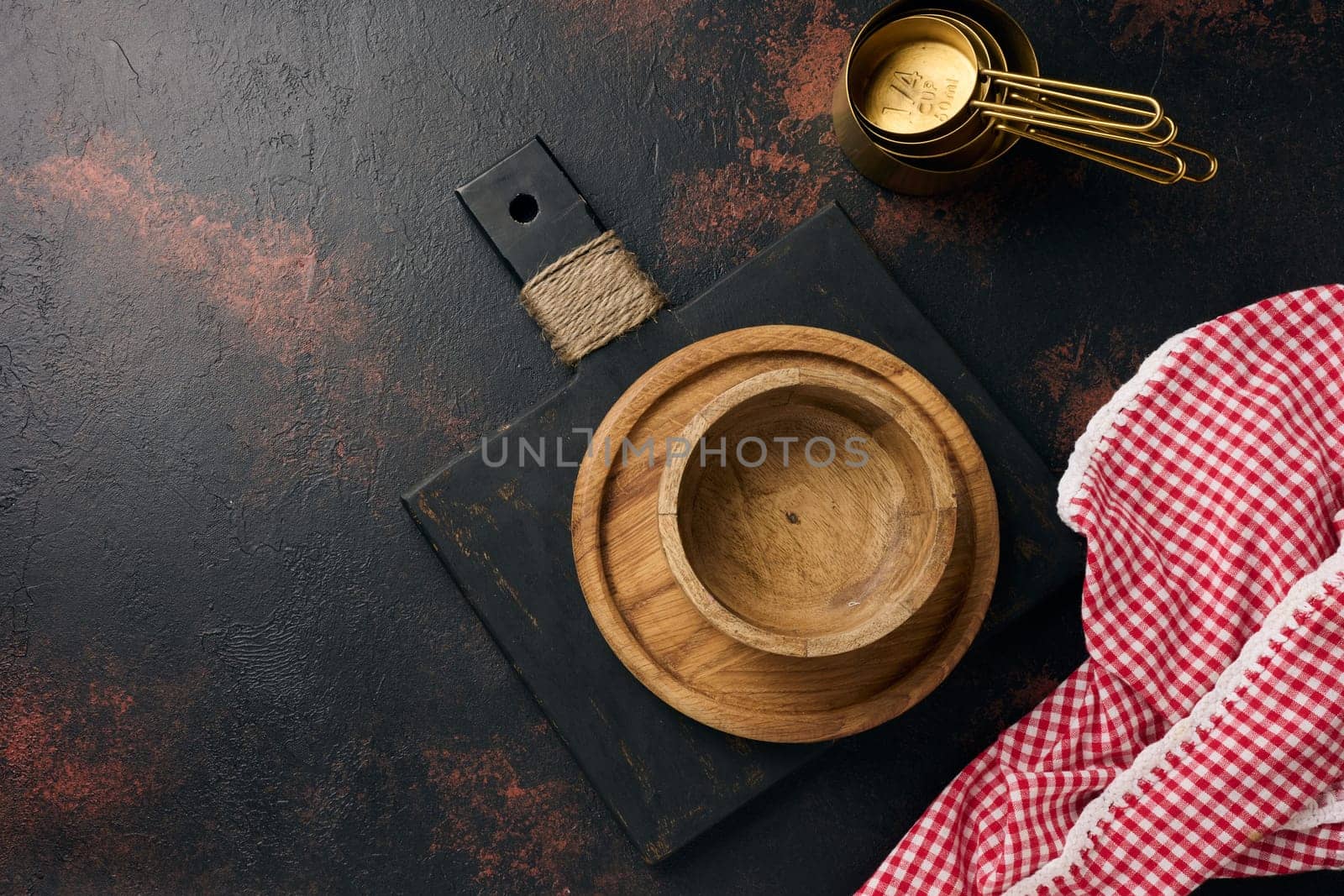 Empty wooden plate and cutting kitchen board on black background, top view