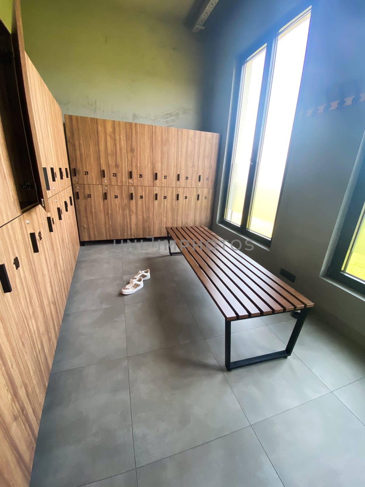 Wooden bench in empty locker room at gym.