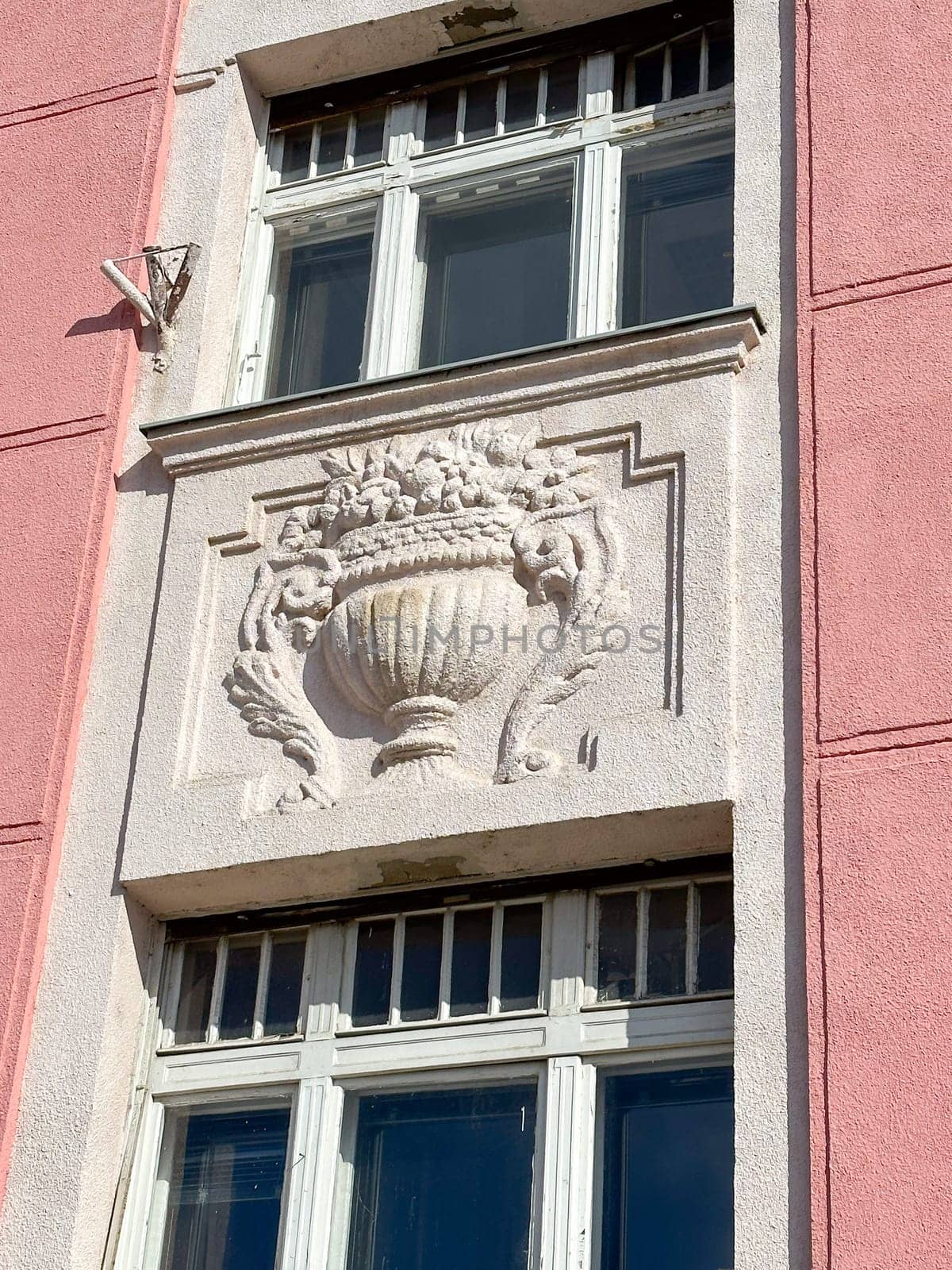 Ornate details of a historic building facade illuminated by sunlight. the intricate architectural elements and pastel colors highlight the building's elegance and charm.