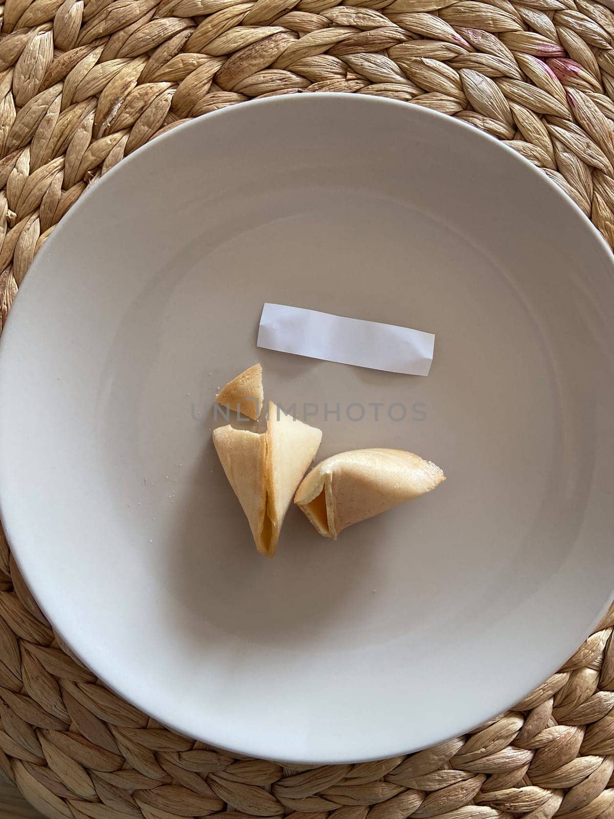Broken fortune cookie with a blank paper slip on a gray background. Moment of anticipation and mystery that accompanies the opening of a fortune cookie.