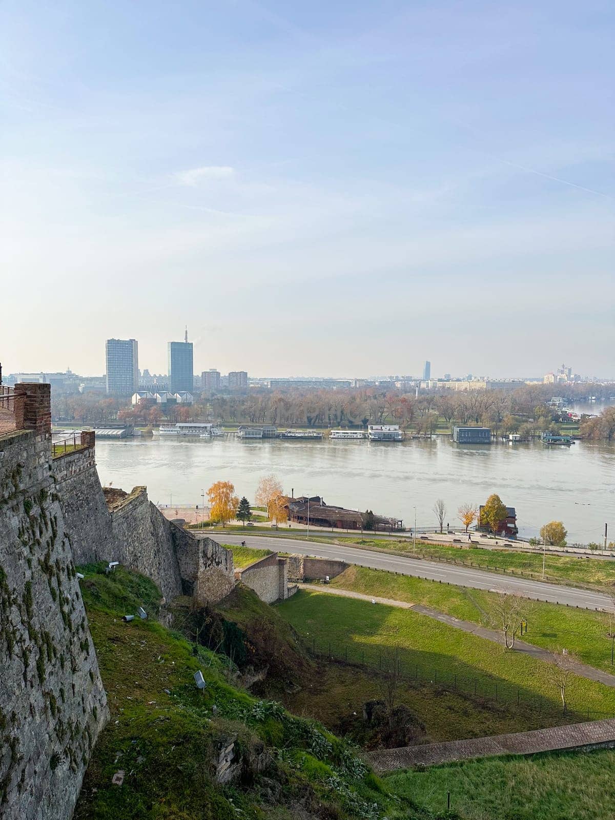 Looking across the Sava river in Belgrade, river boats in the foreground and a variety of office blocks in the distance. Belgrade in autumn season.