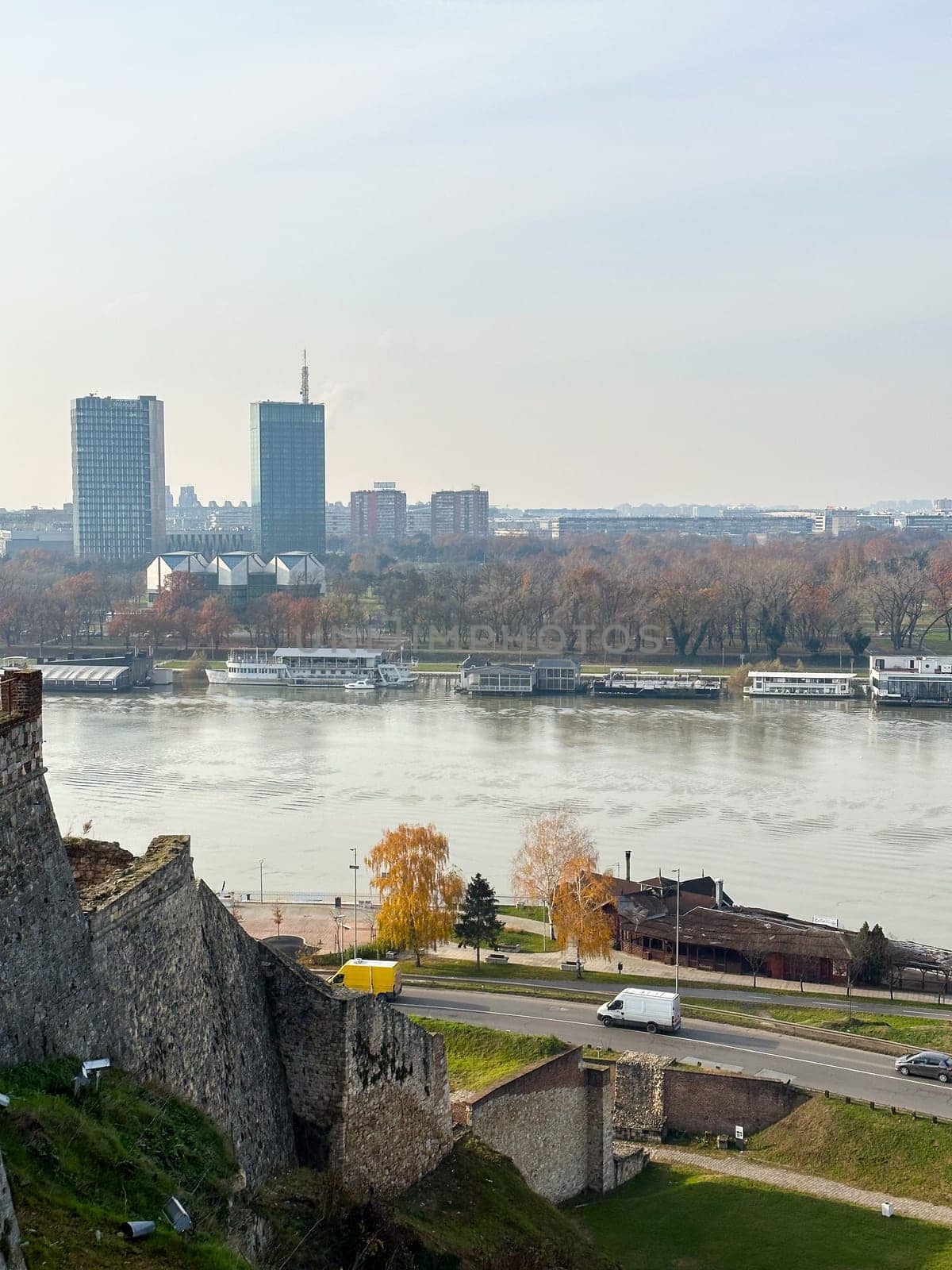 Looking across the Sava river in Belgrade, river boats in the foreground and a variety of office blocks in the distance. Belgrade in autumn season.