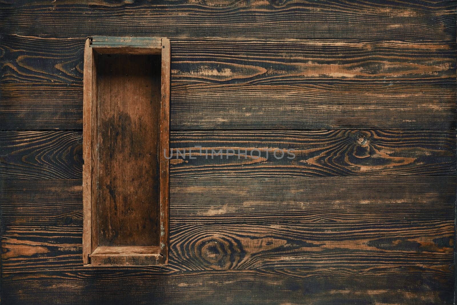 A rustic wooden box on a dark wooden tabletop, showcasing handmade craftsmanship