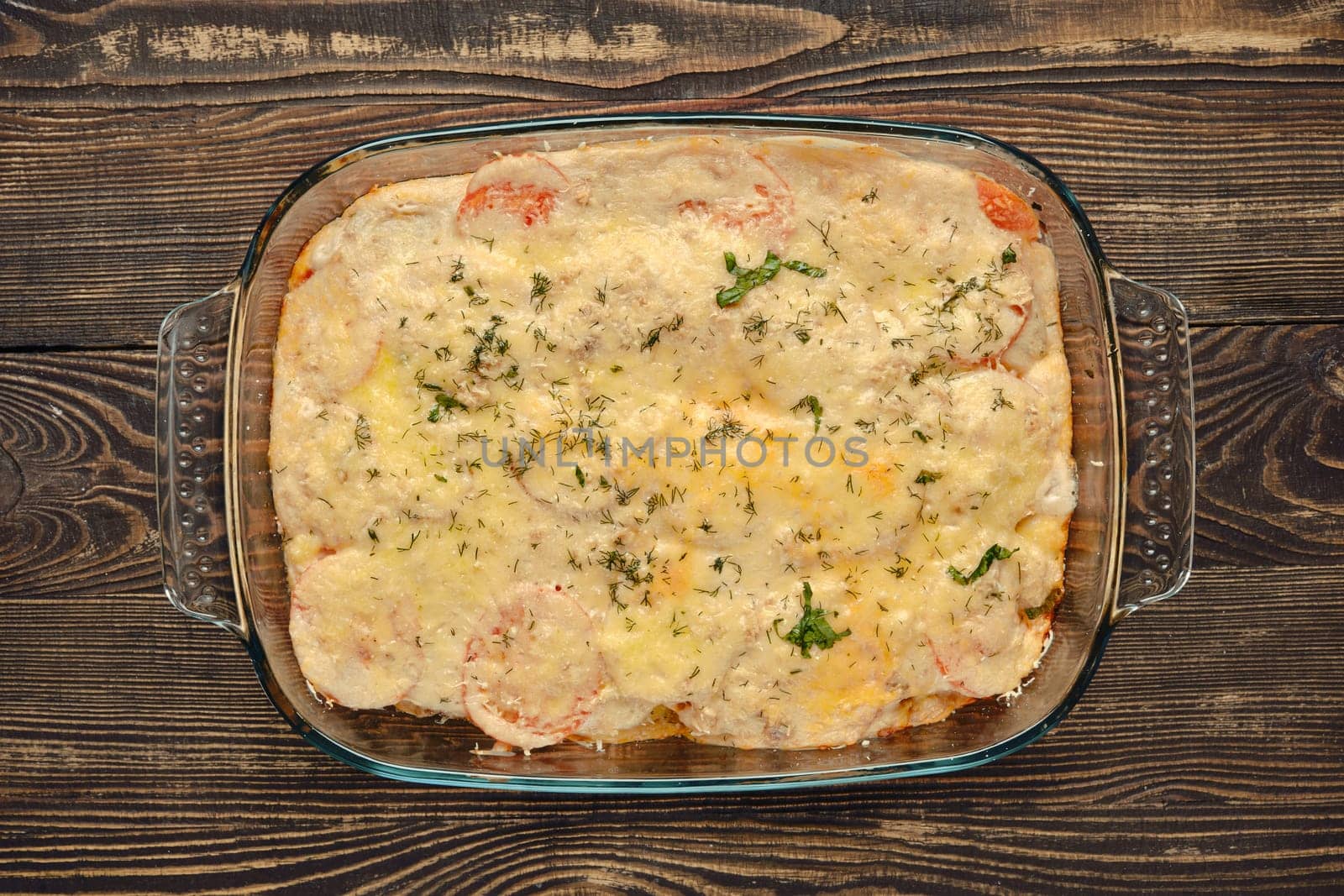 A hearty casserole is freshly baked, featuring layers of colorful vegetables and melted cheese