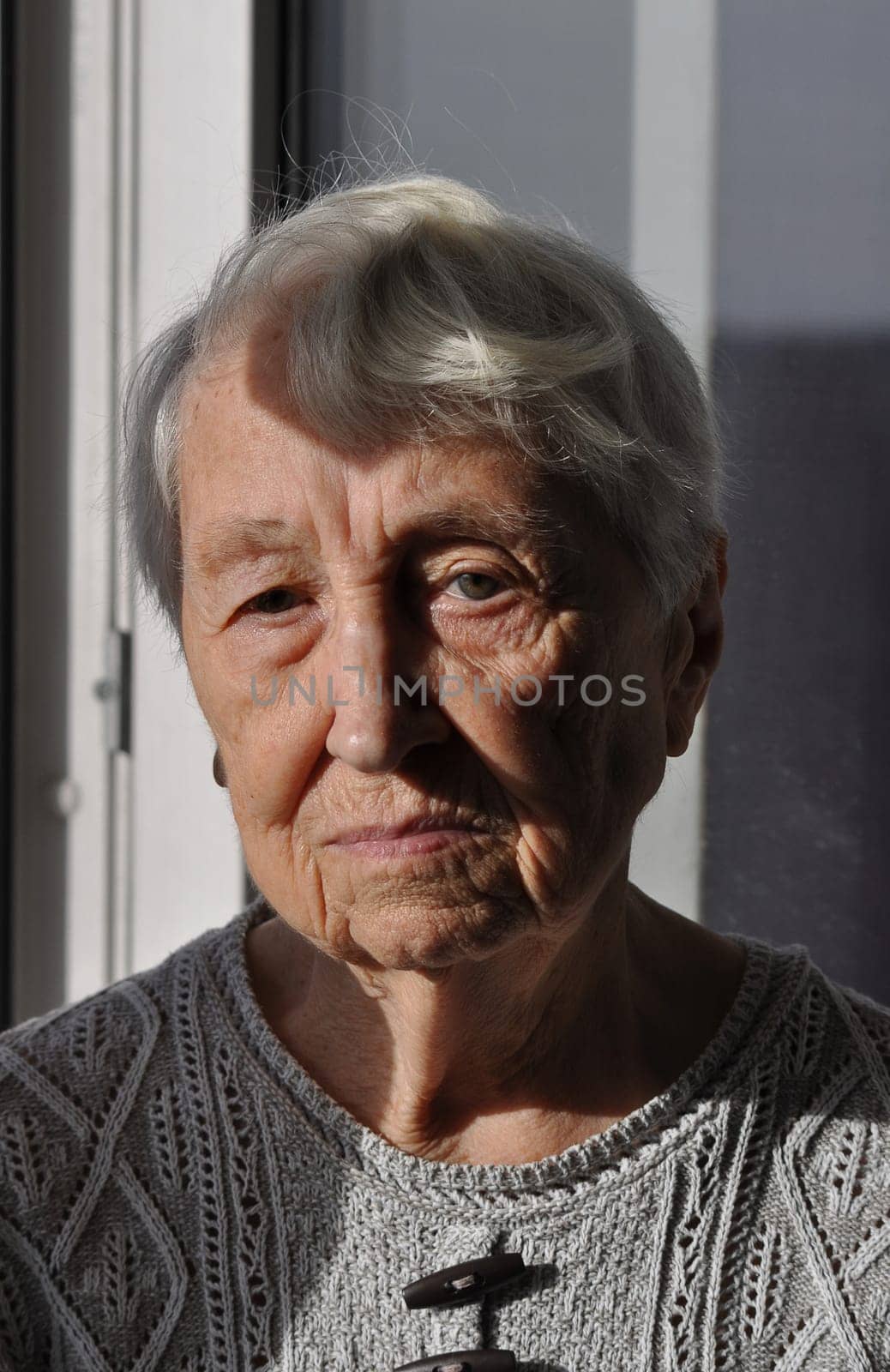Head shot close up portrait of thoughtful senior woman worrying about personal health problems. Upset older female thinking of family troubles, feeling lonely, sitting at home.