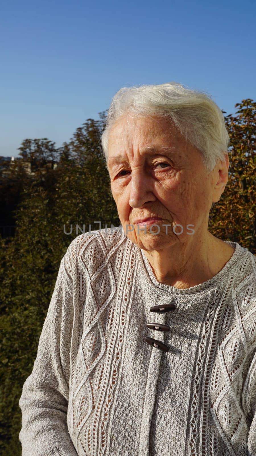 Portrait of beautiful senior woman posing in autumn park