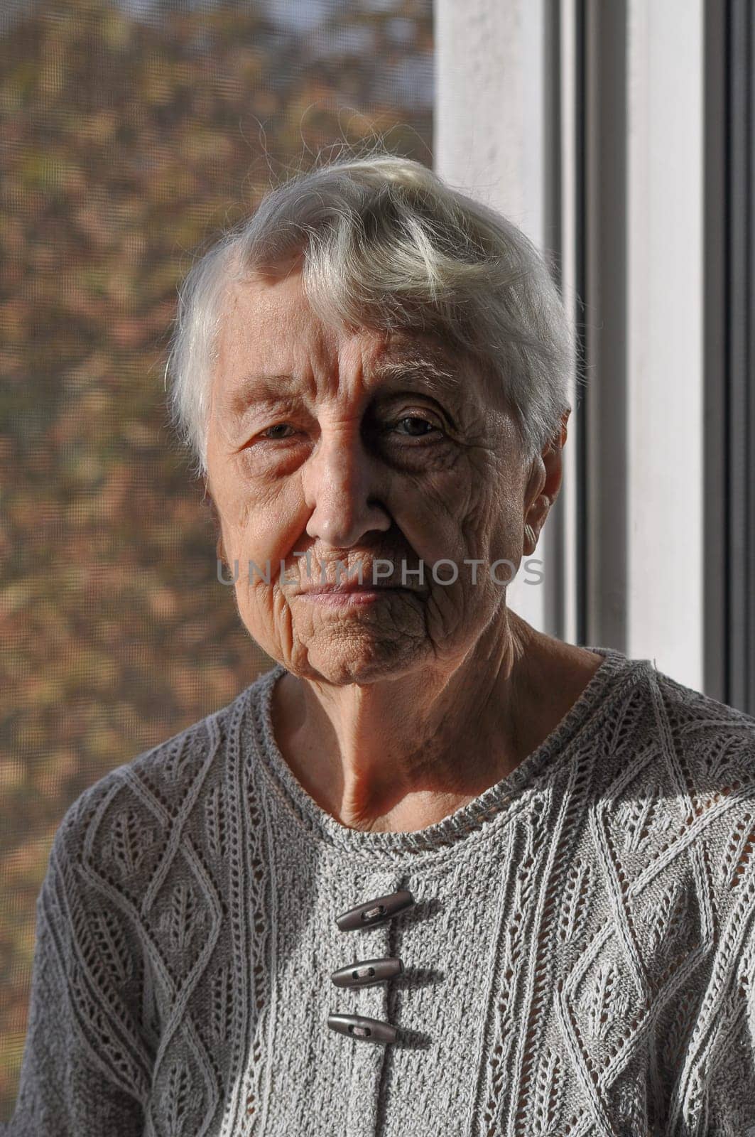 Head shot close up portrait of thoughtful senior woman worrying about personal health problems. Upset older female thinking of family troubles, feeling lonely, sitting at home.