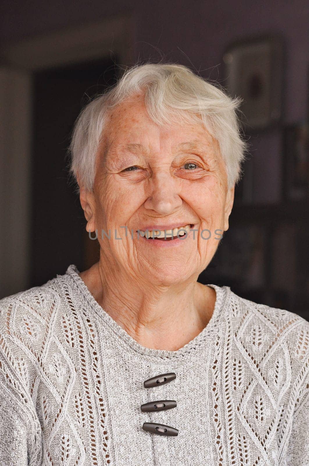 Portrait of elderly woman near window, Grandmother smiling