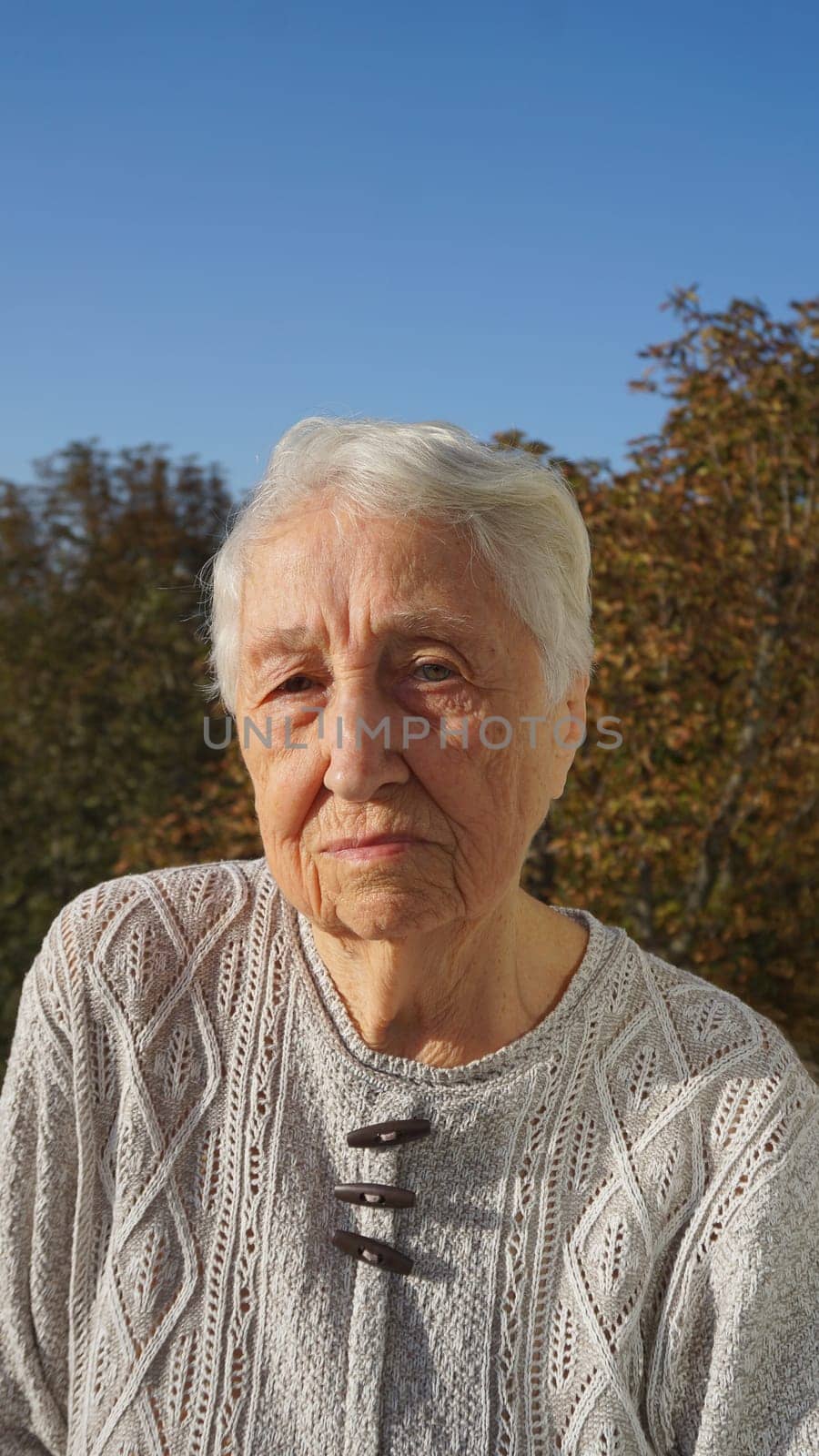 Portrait of beautiful senior woman posing in autumn park