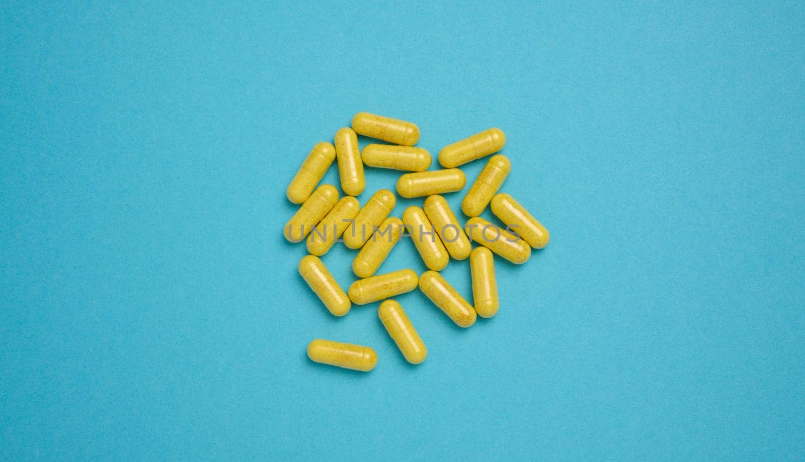 Yellow pills in a capsule on a blue background, pain treatment