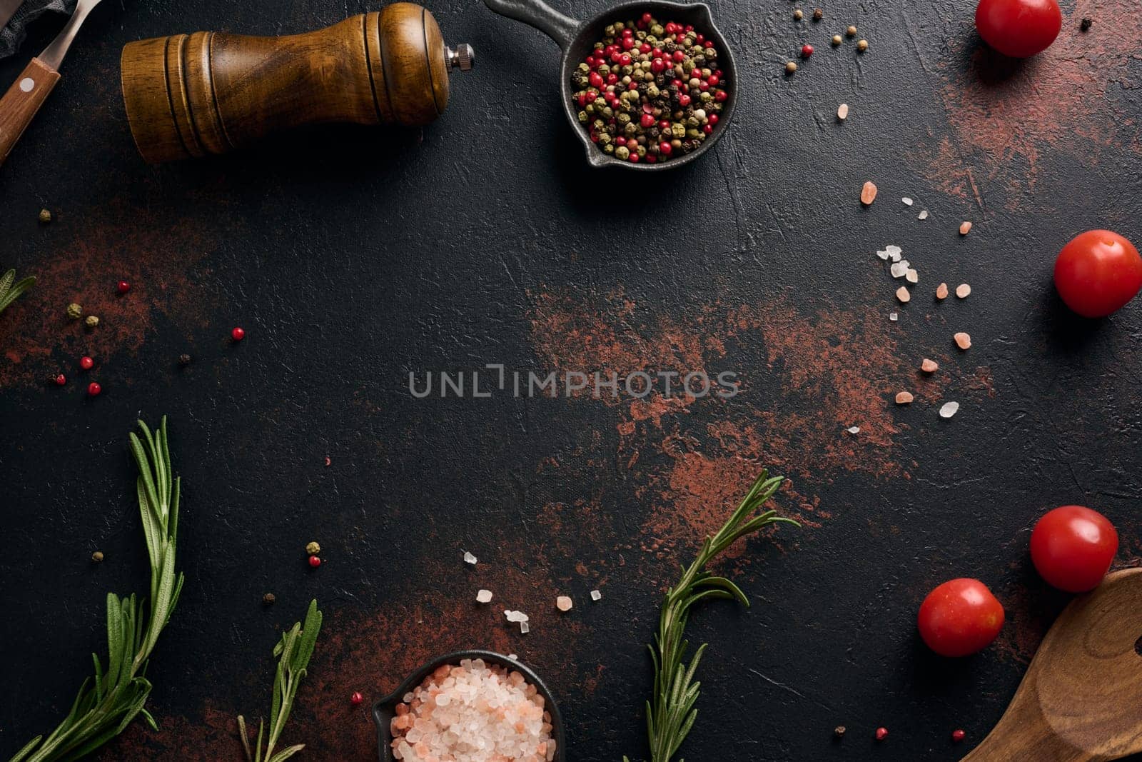 Culinary composition with kitchen utensils and spices, Himalayan salt, colorful peppercorns, fresh rosemary on the table. Top view, copy space