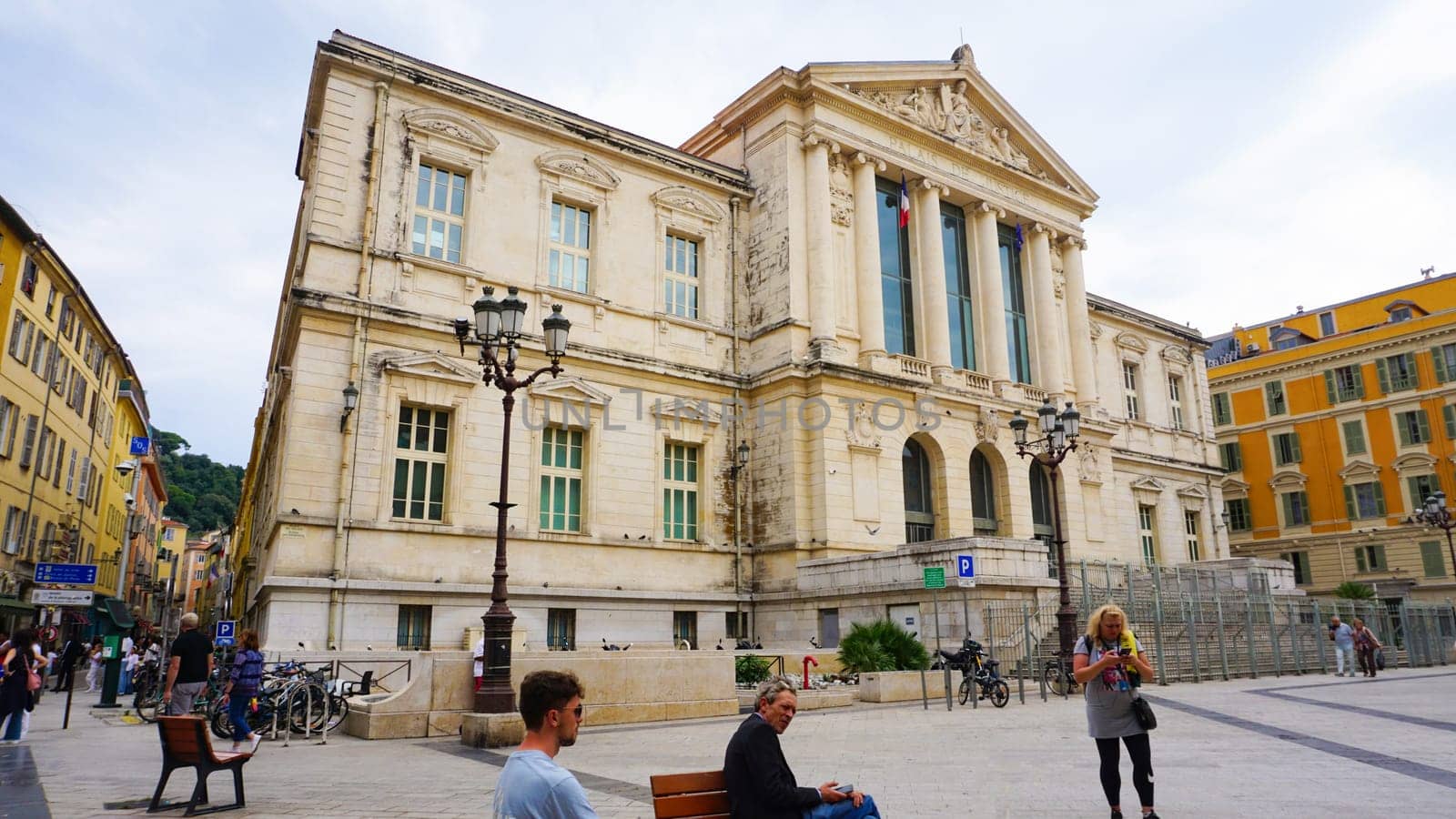 Nice, France - September 22, 2024: People going near Palais de Justice in Nice, France, featuring grand columns and intricate sculptures.