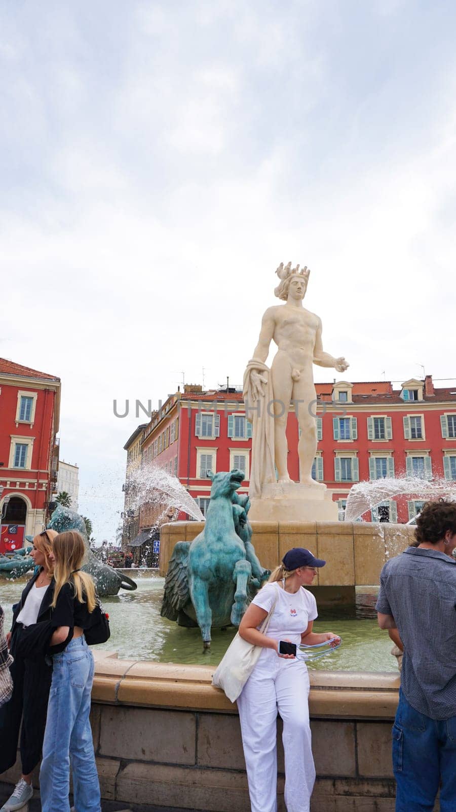 Nice, France - September 22, 2024: People going at Place Massena - people, transport and architecture in cloudy weather, city views of Nice, French Riviera, France