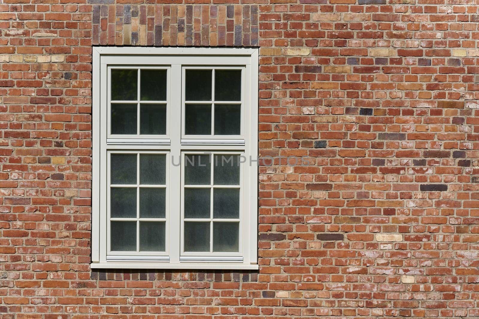 Window with white frame on a historic brick building in Germany