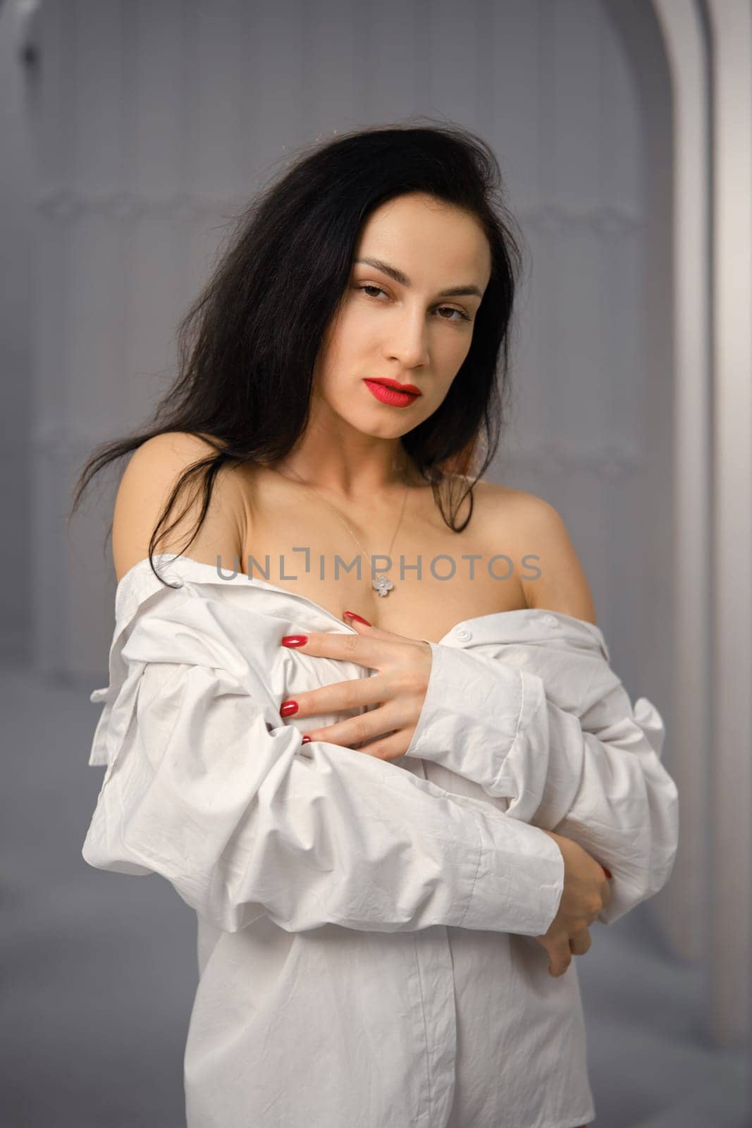 Portrait of playful charming woman in a lowered white shirt