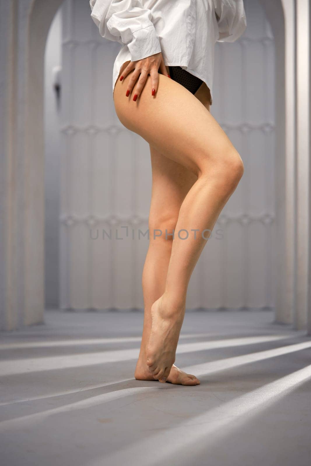 Bare female legs in a room with columns, low angle view