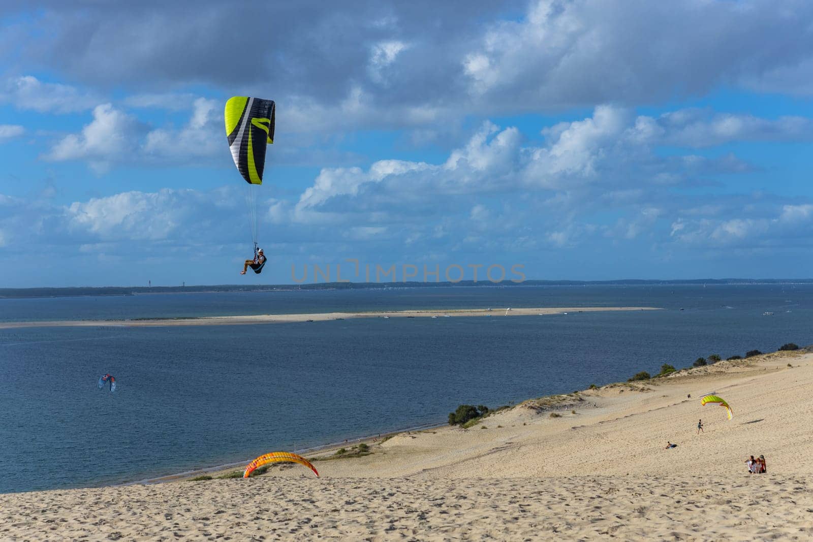 Dune of Pilat, France - August 14, 2024: People paragliding at the Great Dune of Pilat, Arcachon Basin, Nouvelle Aquitaine, France.