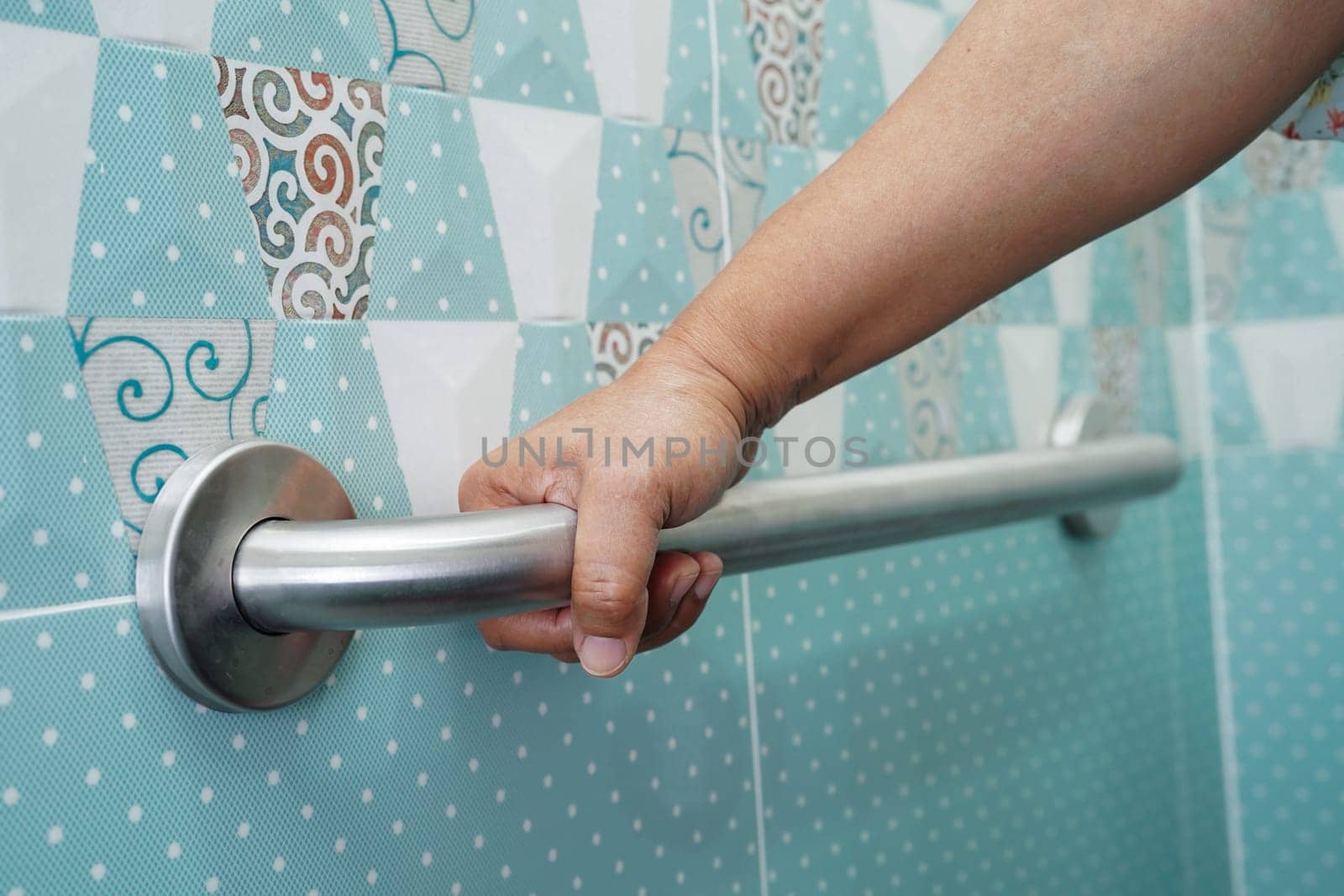 Asian elderly old woman patient use toilet support rail in bathroom, handrail safety grab bar, security in nursing hospital.