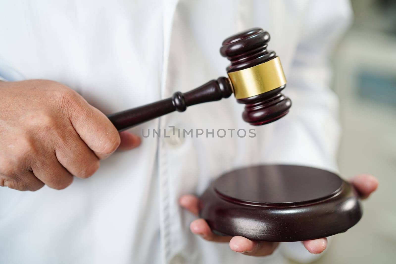 Asian doctor holding court hammer for and crime law justice, forensic medicine.