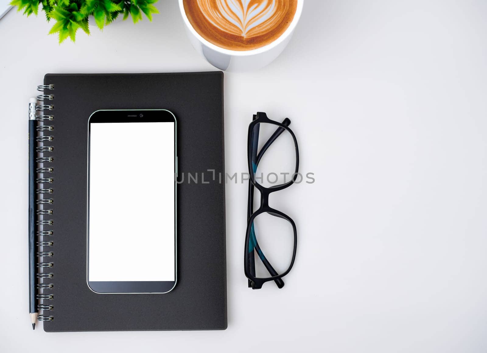 Top view of mock up modern workspace with blank screen smartphone, Coffee cup, Notebook, Pencil, Glasses. Office situation with keyboard and accessories isolated on white. Copy space, Flat lay.