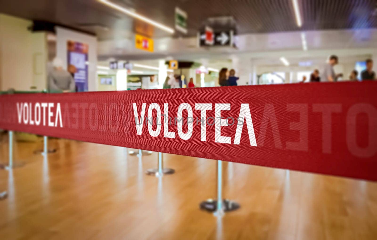 Barcelona, ES, May 22 2022  Close-up of Volotea branded ribbon at an airport check-in area. The red ribbon prominently displays the airline logo.