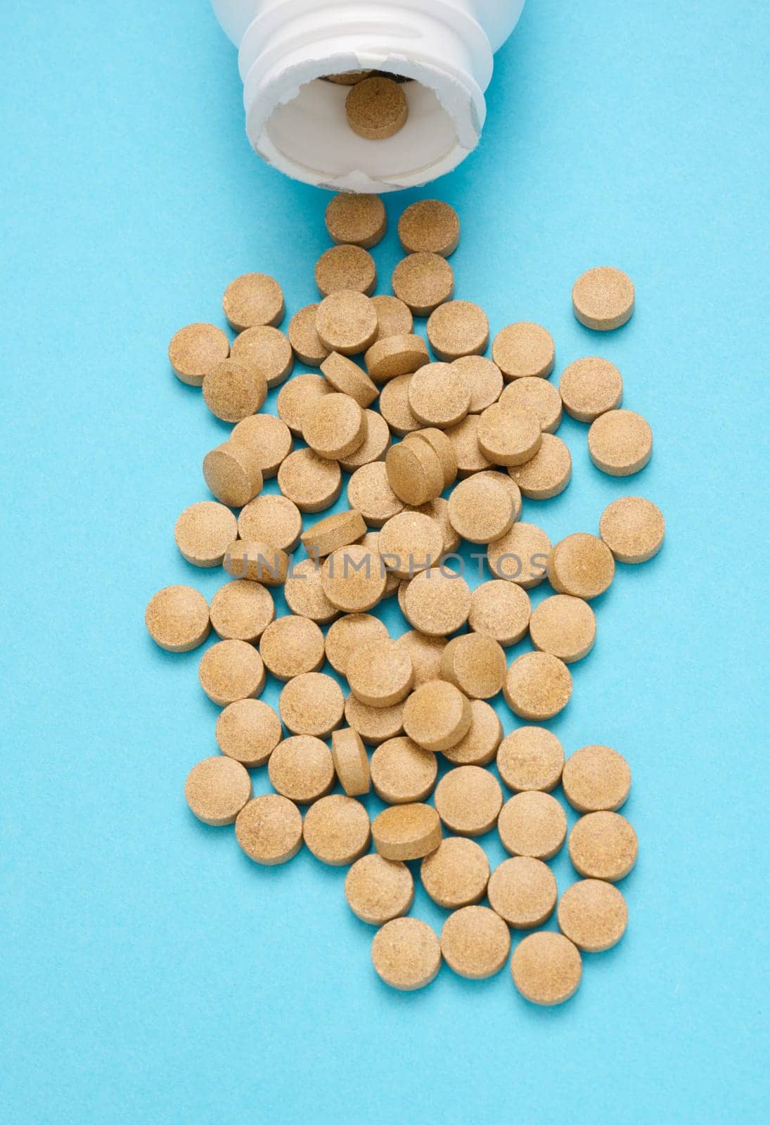 Yellow round pill for healthcare. Medical treatment, blue background, top view