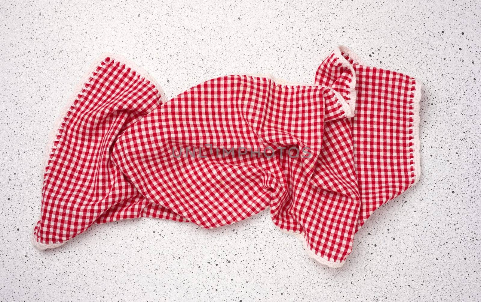 Folded red kitchen towel on a white background, top view.