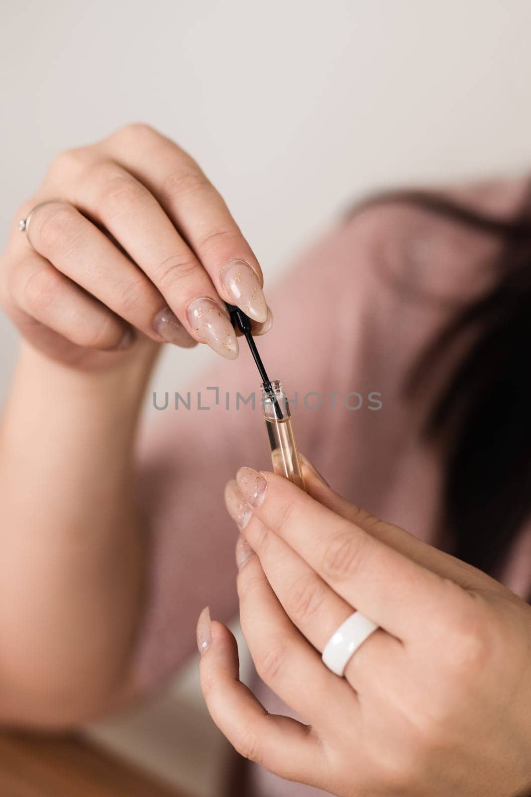Detailed close-up view of hands skillfully using an elegant perfume sampler applicator