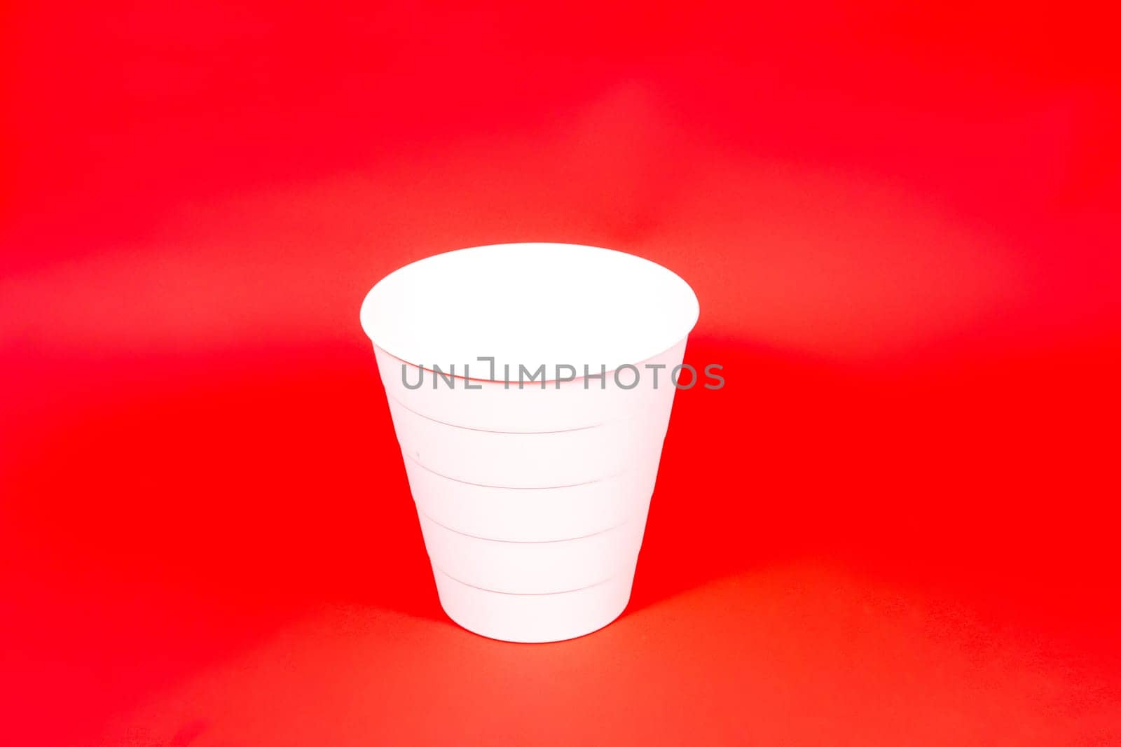 White buckets isolated on red background in a studio