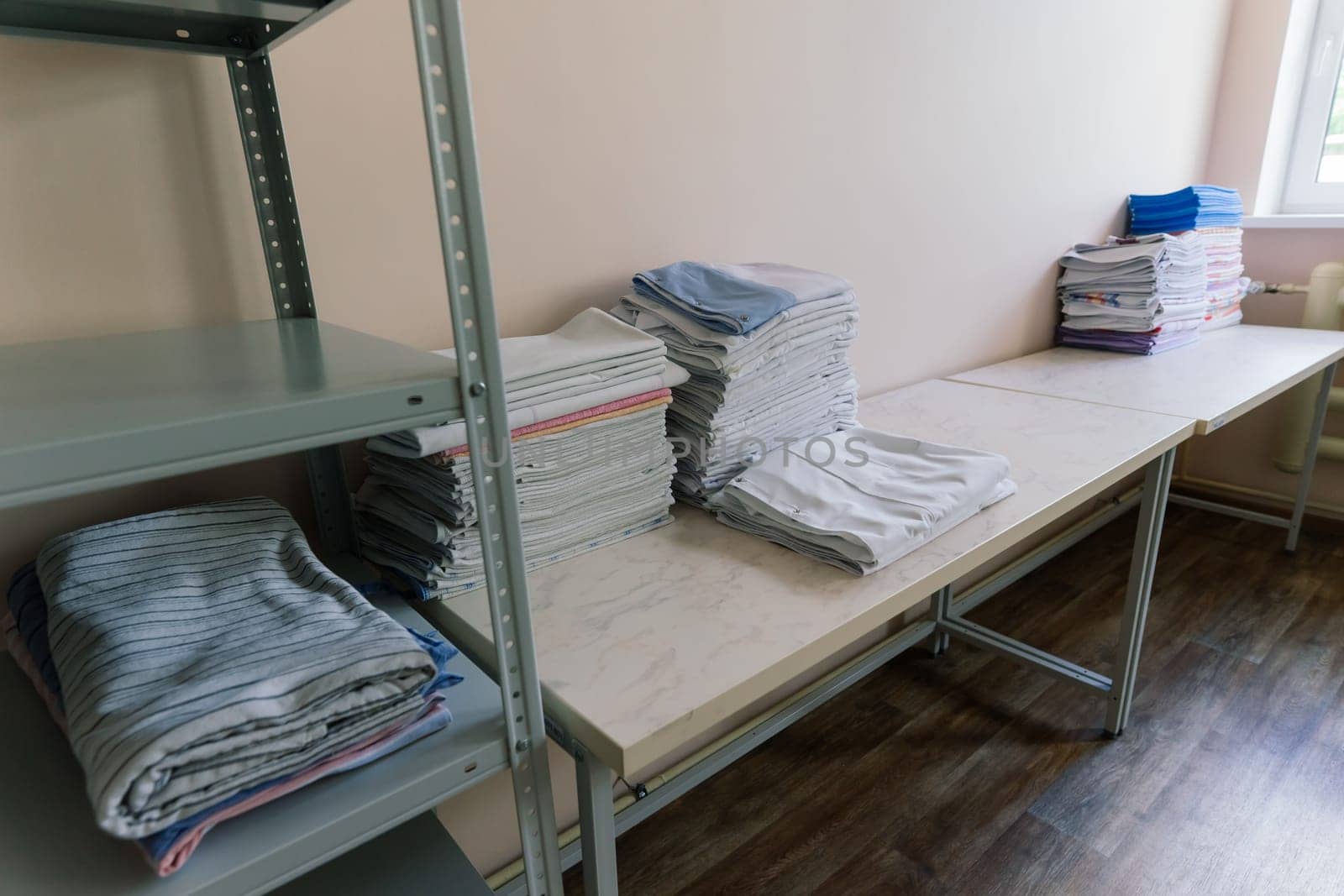 Linens piled neatly on the shelves. There are folded bed sheets, towels, wash clothes