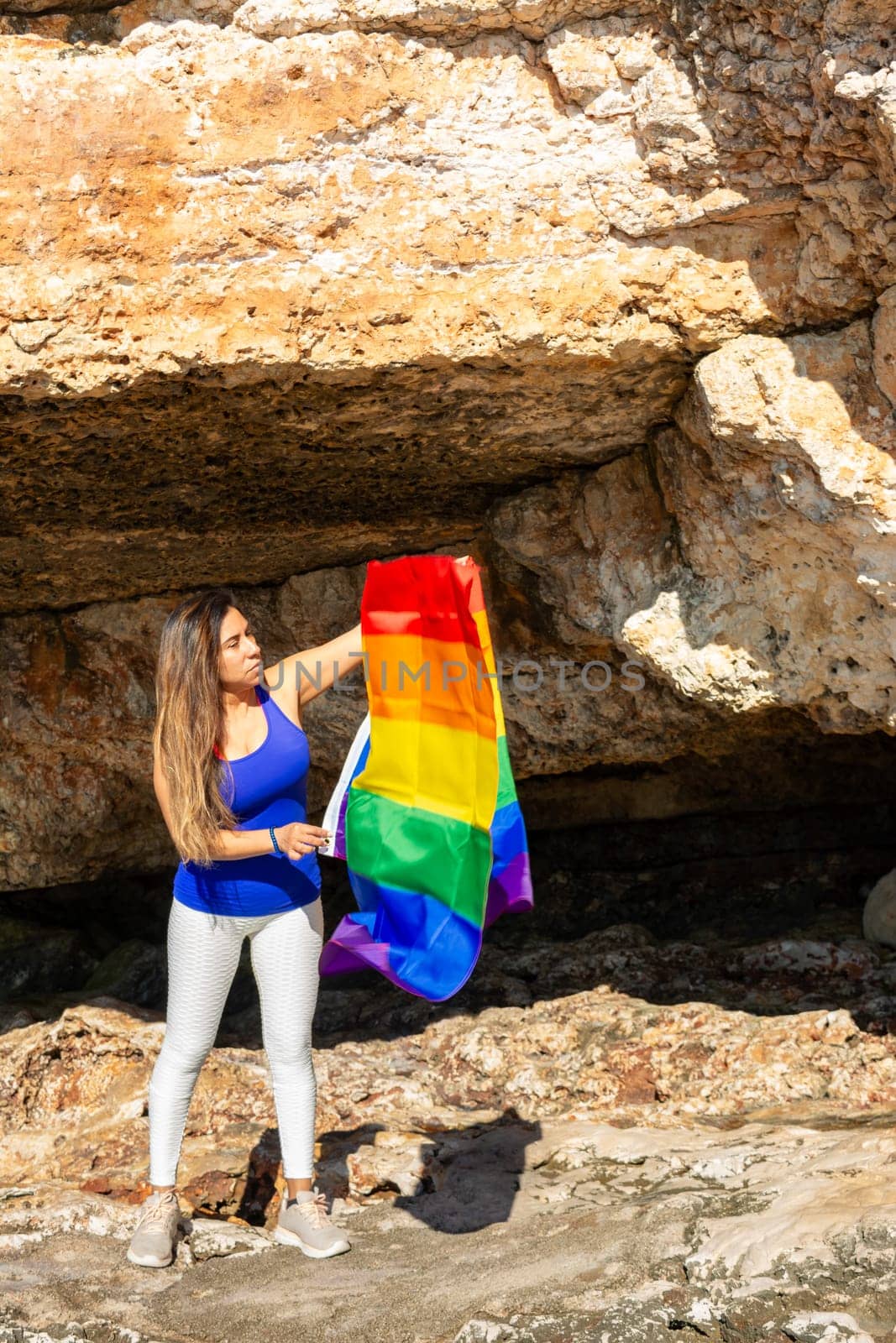woman, middle aged, outdoors waving pride flag, concept of libertat, equality.