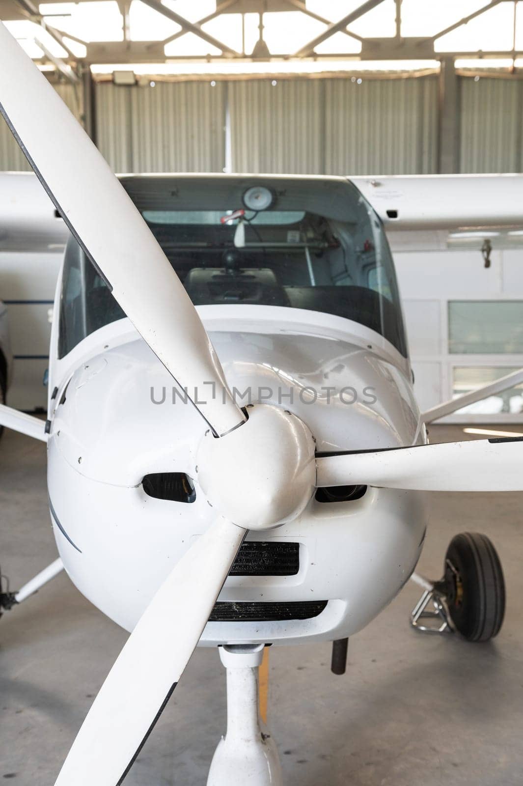 Small private lightweight propeller airplane in hangar, closeup photo