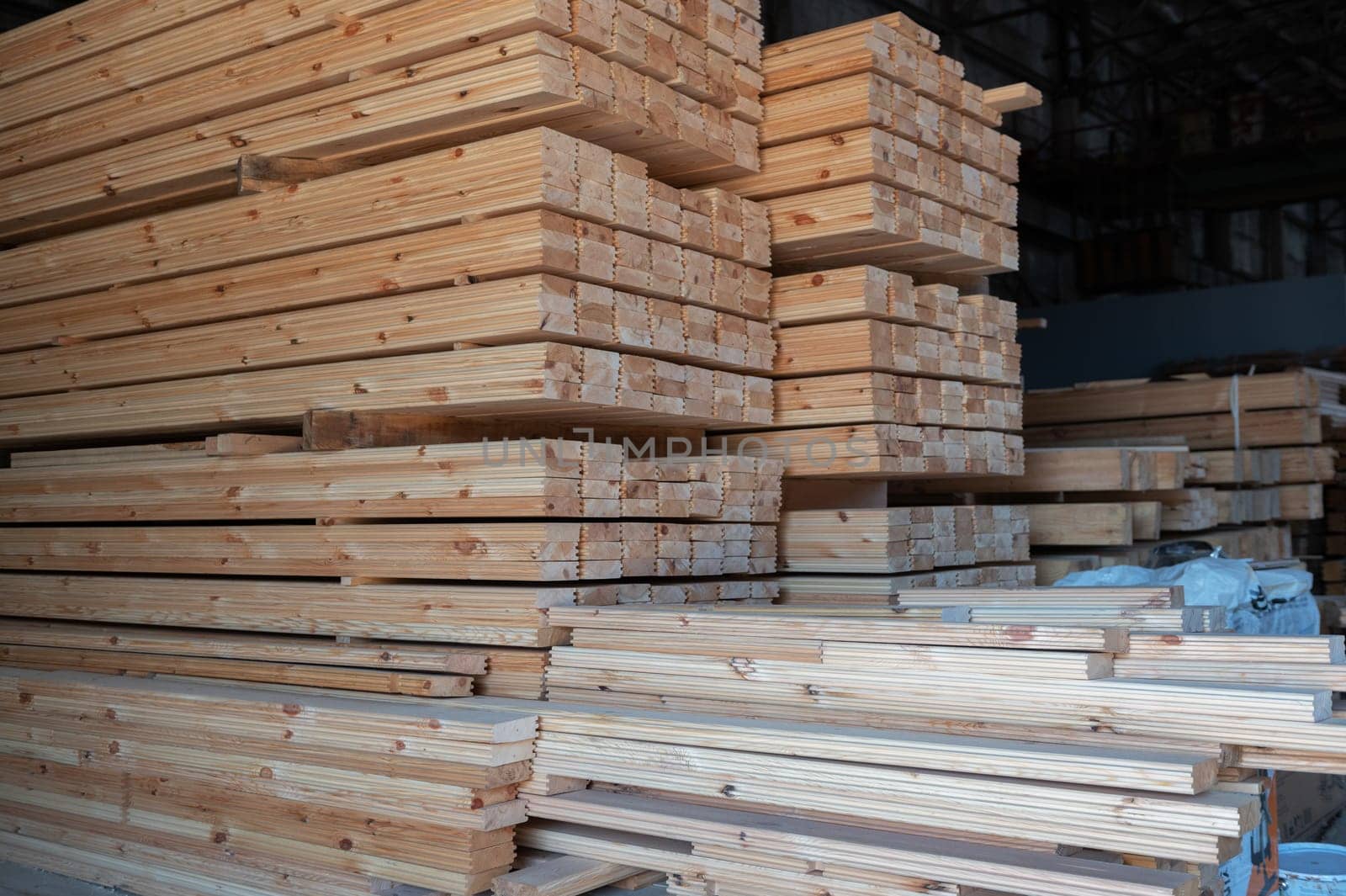 Stacked wooden planks close-up at lumber warehouse. Wood industry concept