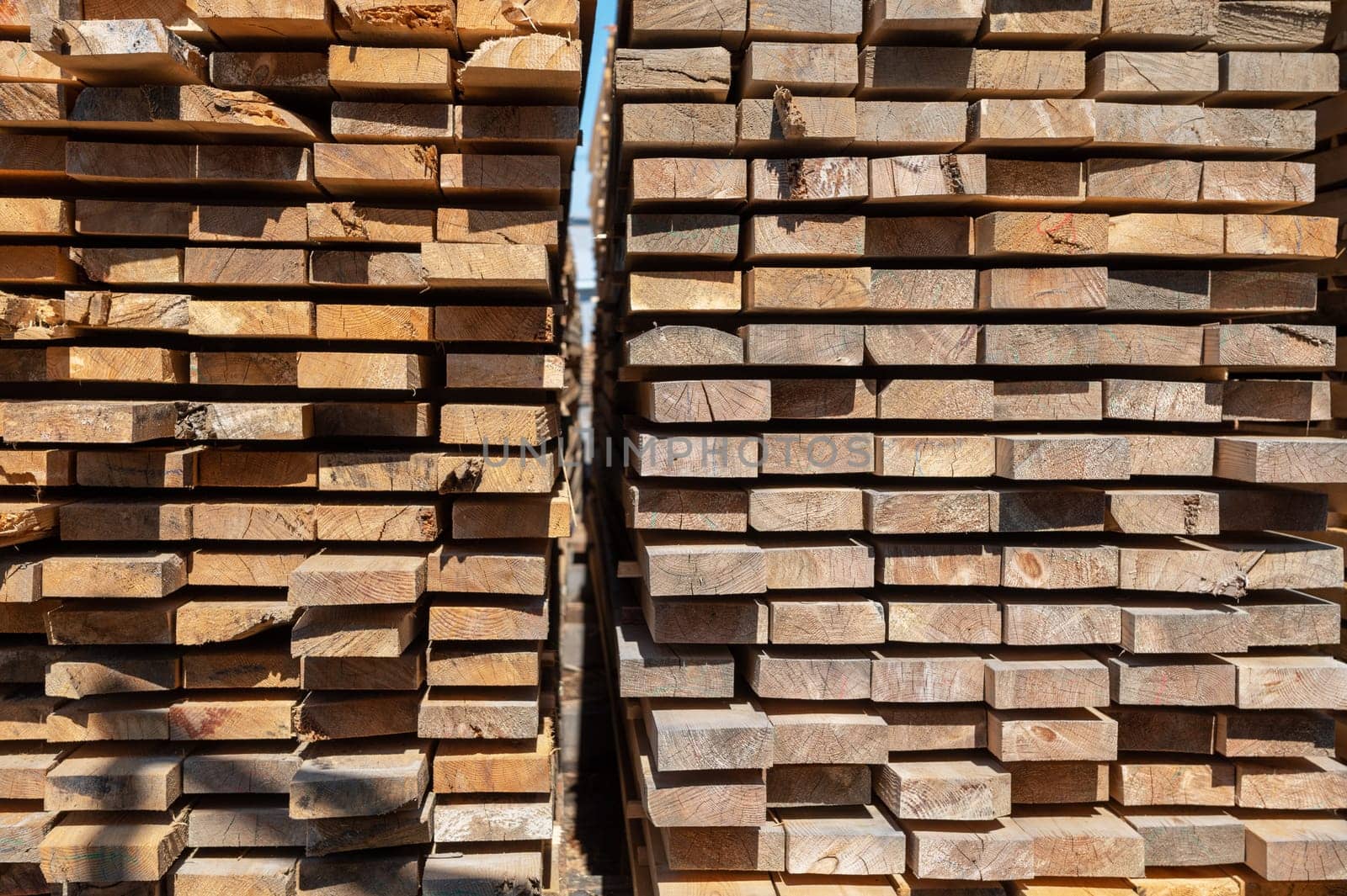 Stacked wooden planks close-up at lumber warehouse. Wood industry concept