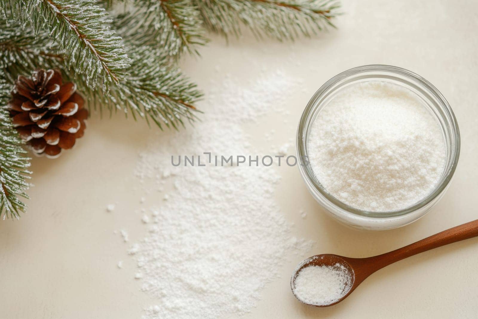 A jar of powdered substance sits beside pine branches and a pine cone creating a winter themed atmosphere perfect for festive decoration.