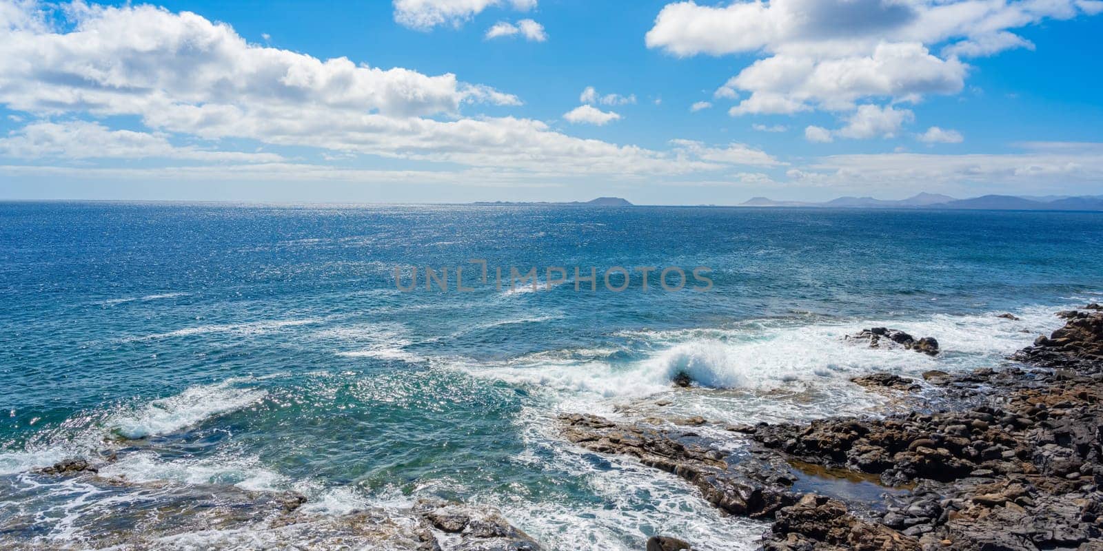 Rocky coastline at Playa Blanca with a view of the beautiful blue Atlantic Ocean on Lanzarote