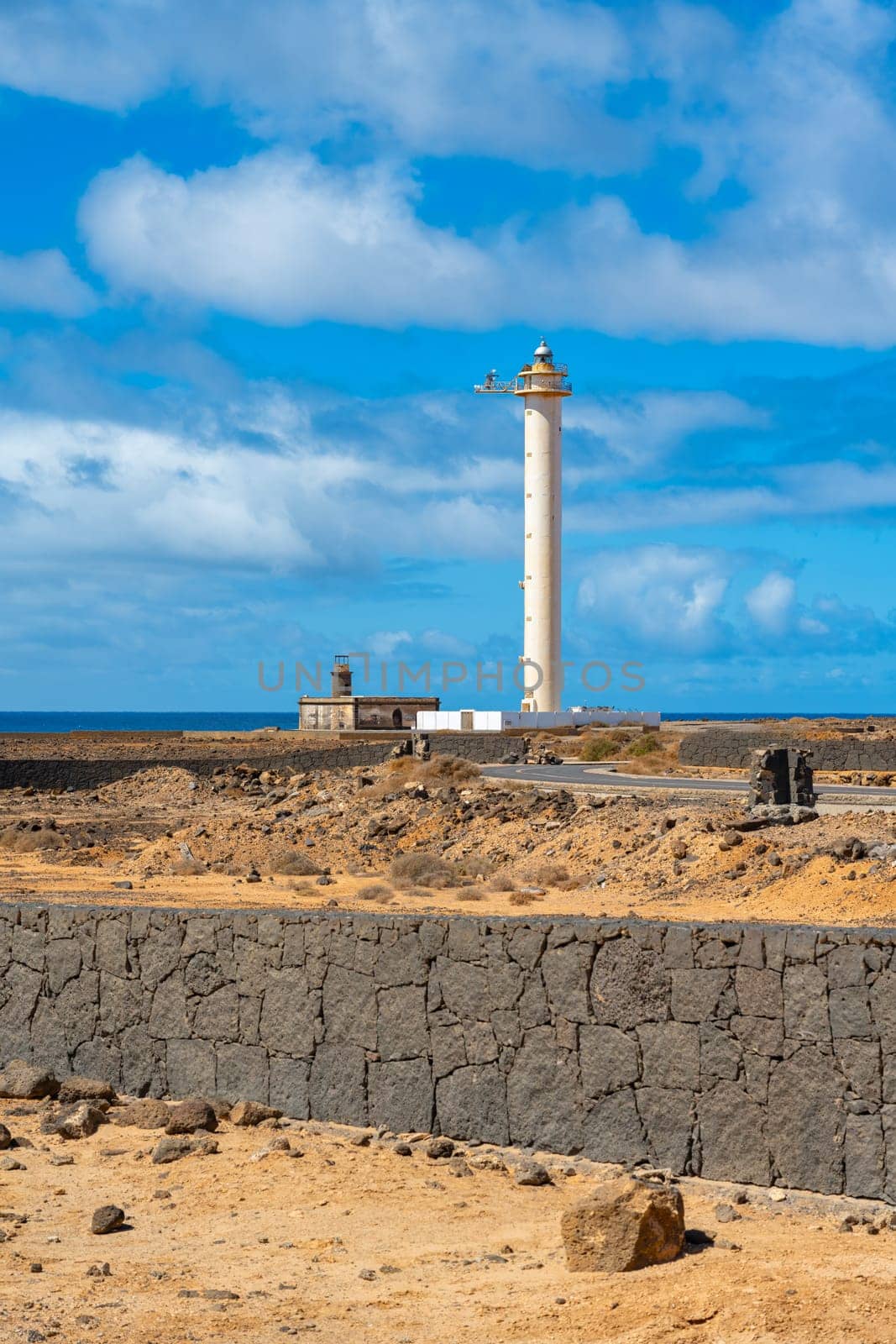 The Faro de Punta Pechiguera lighthouse on Playa Blanca on Lanzarote in front of a blue sky