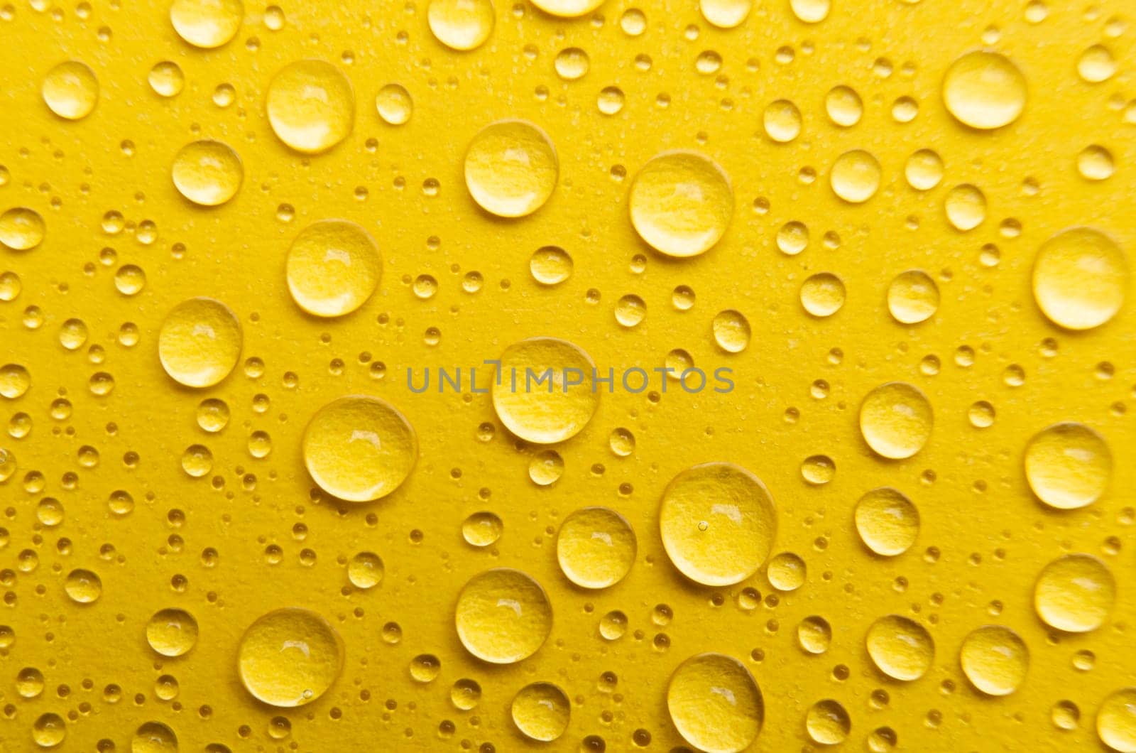 Rain droplets on yellow color background suitable for wallpaper decoration or design.