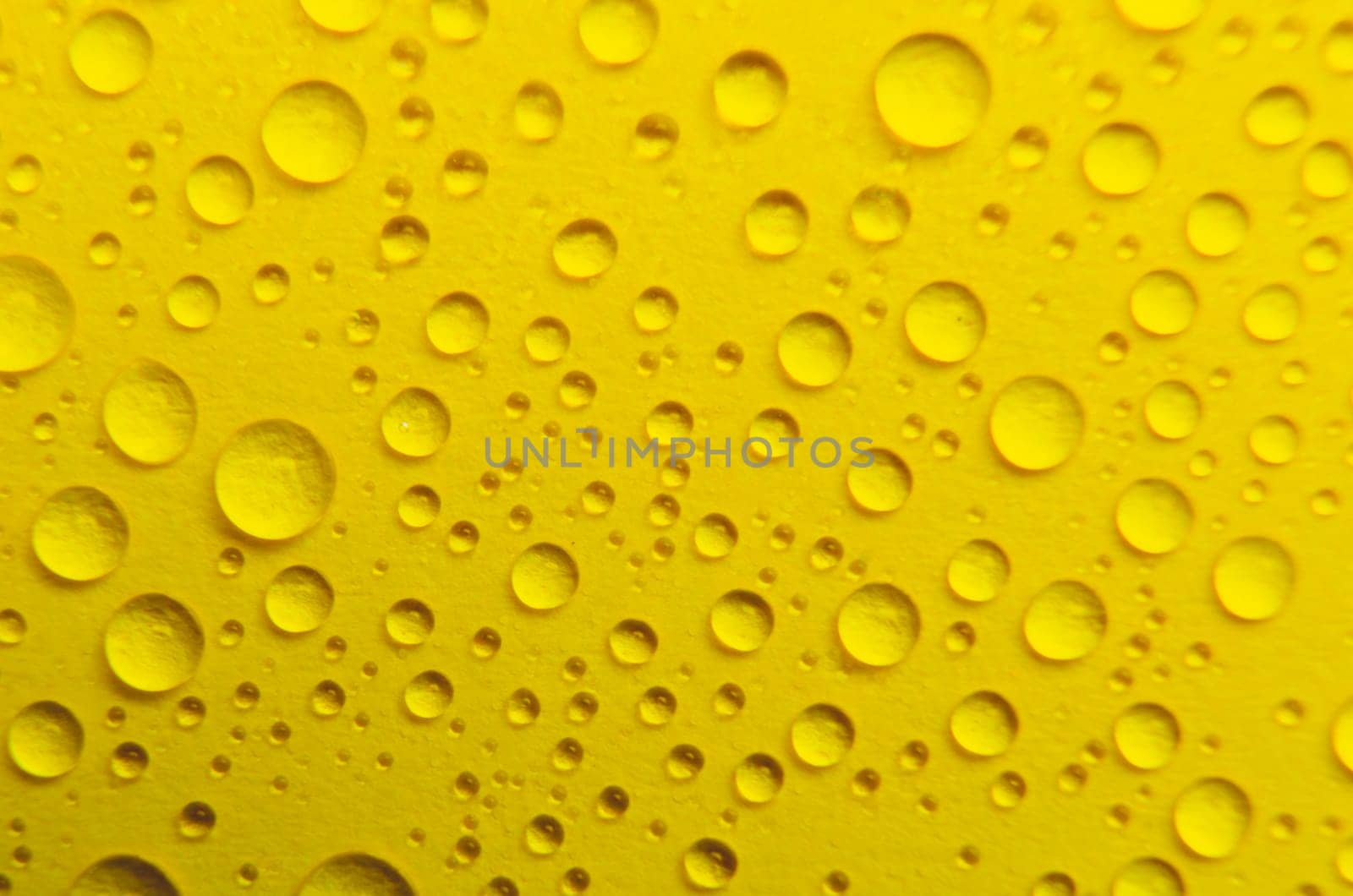 Close up of rain droplets on yellow cover background. Suitable for wallpaper background.