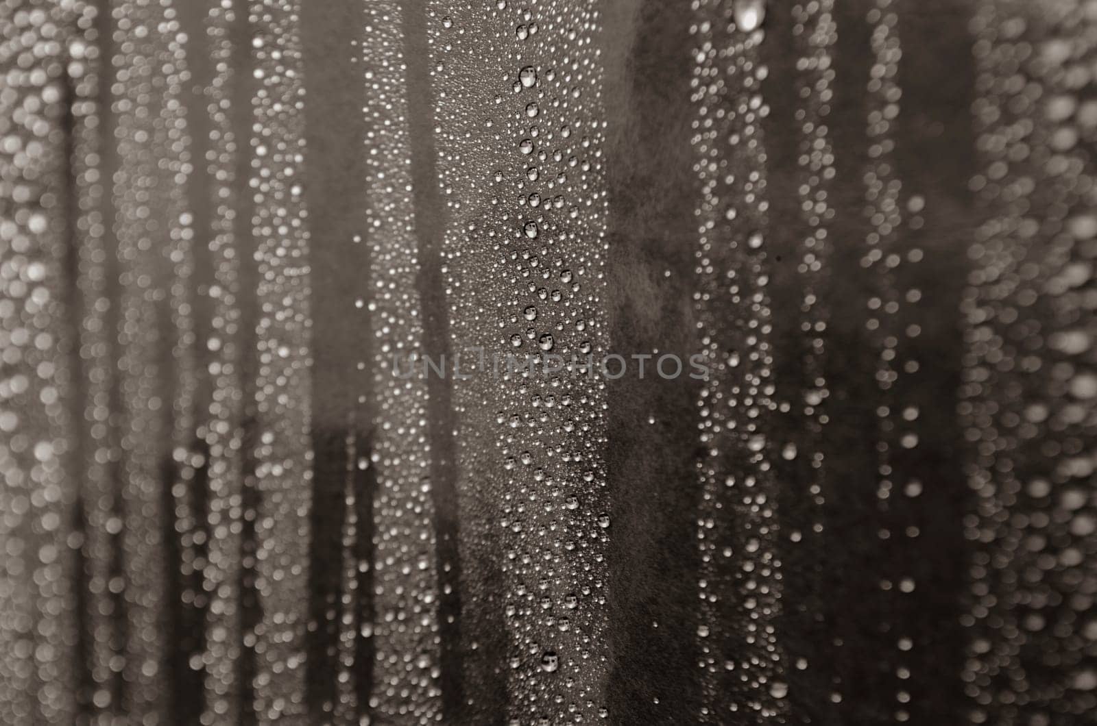 Rain droplets on dark background suitable for wallpaper decoration or design. Water droplets concept.