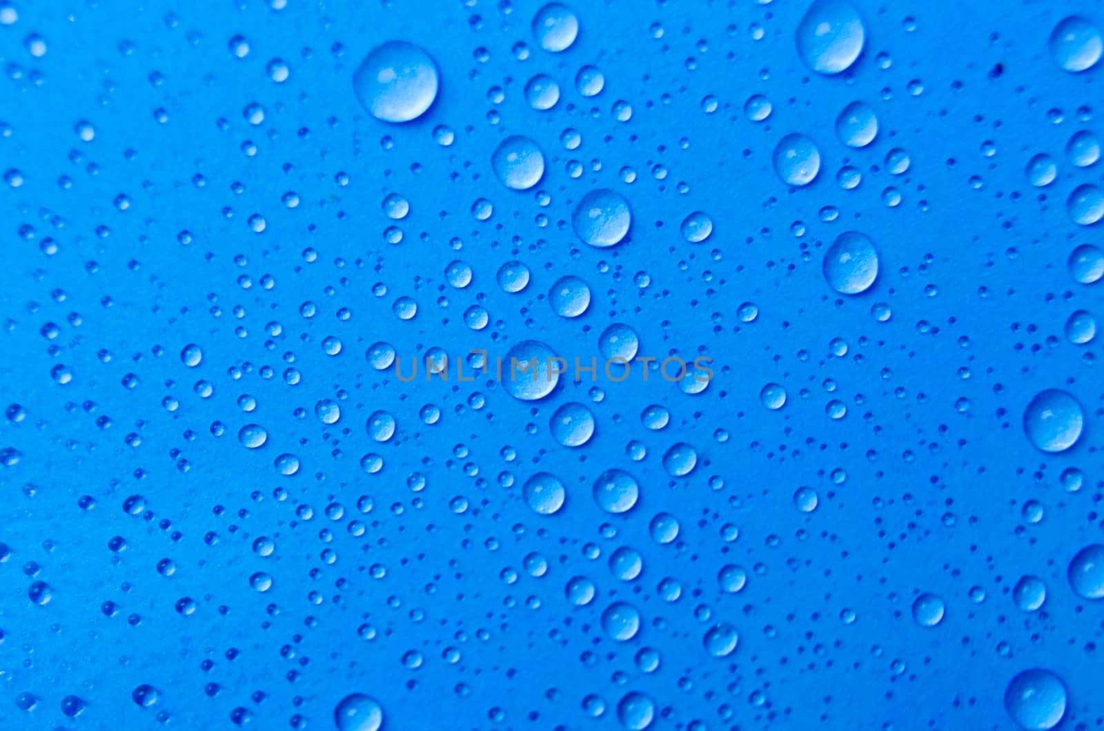 Close up of rain droplets on blue cover background. Suitable for wallpaper background.