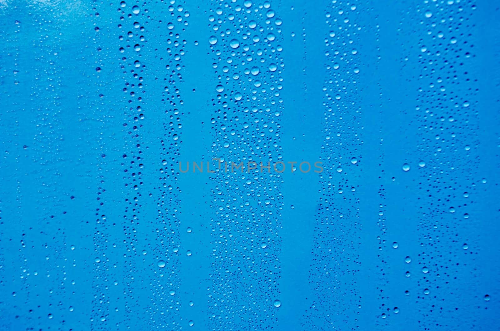 Close up of rain droplets on blue cover background. Suitable for wallpaper background
