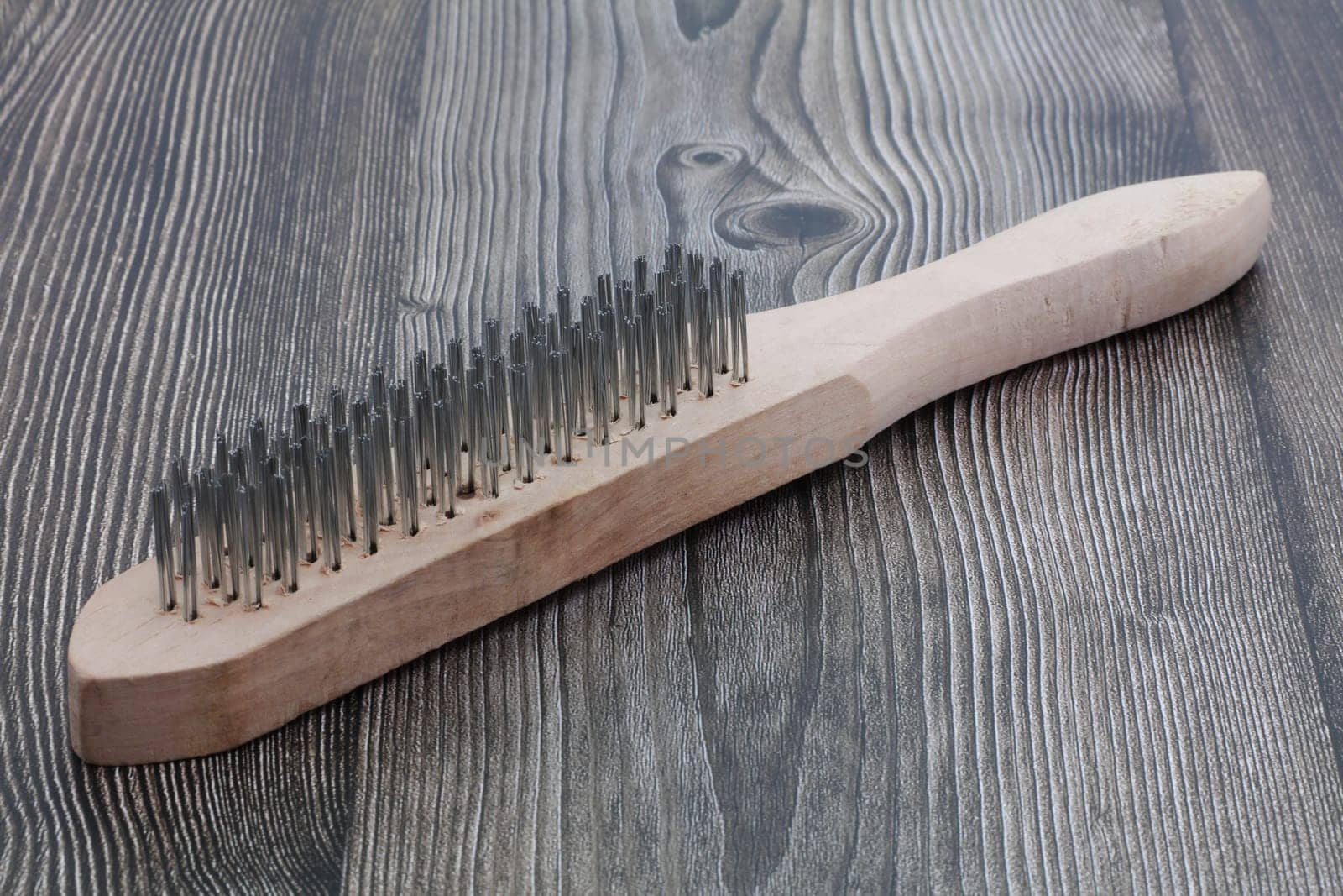 A wire brush on wood surface